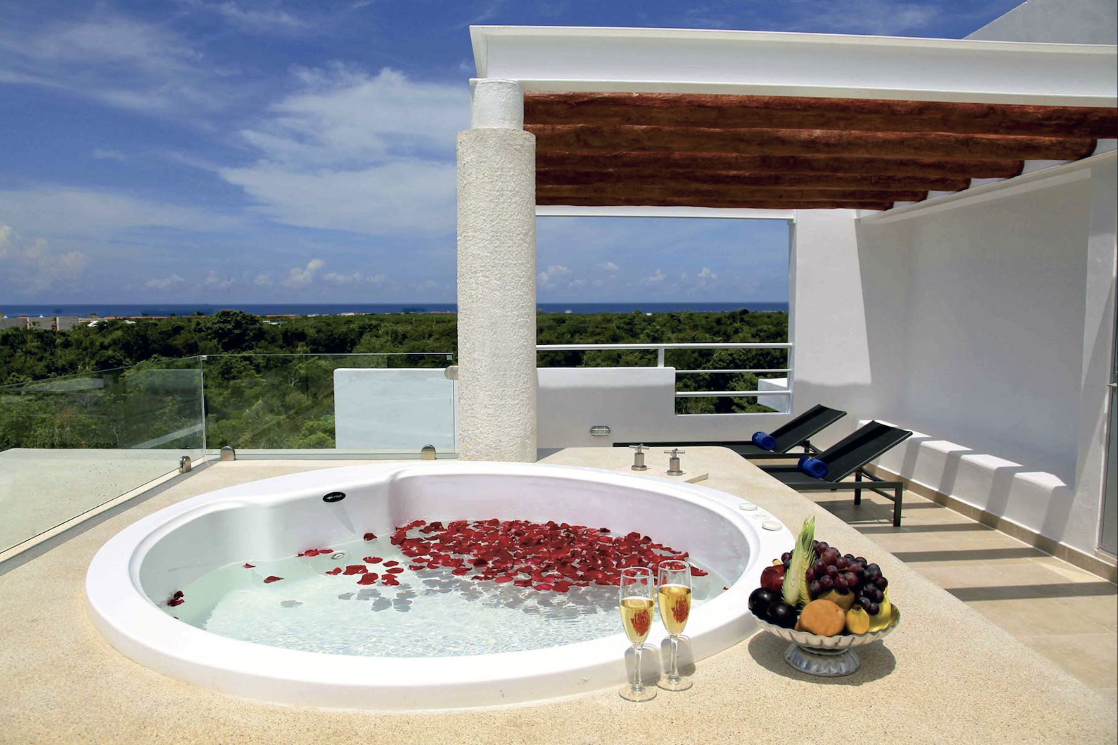 hot tub with flowers petals, champagne overlooking jungle and ocean
