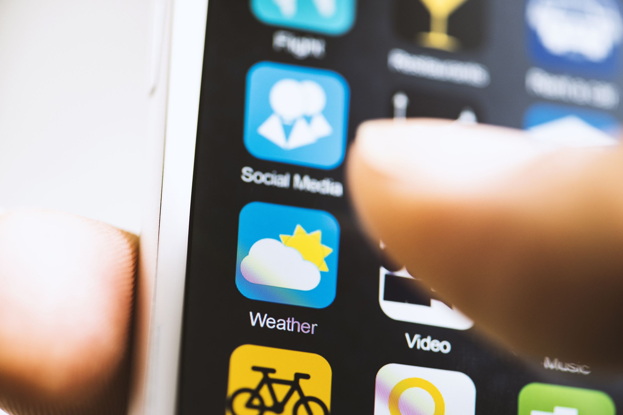 Closeup of finger touching the weather app on a phone