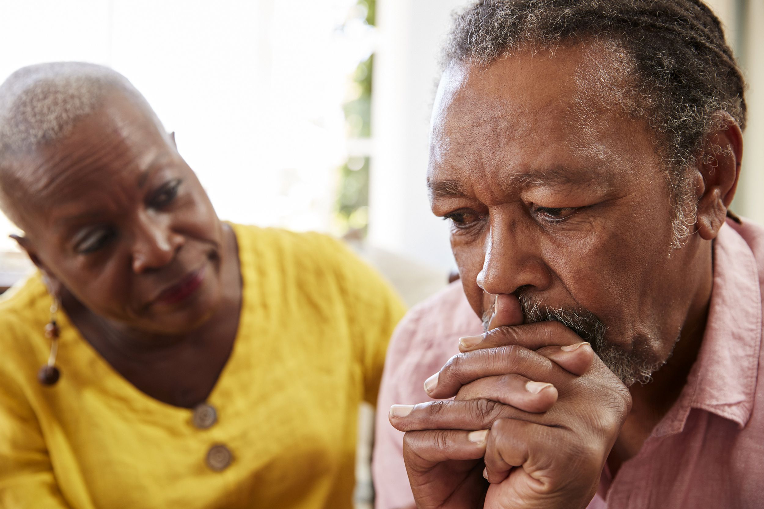 Older woman consoling her depressed husband