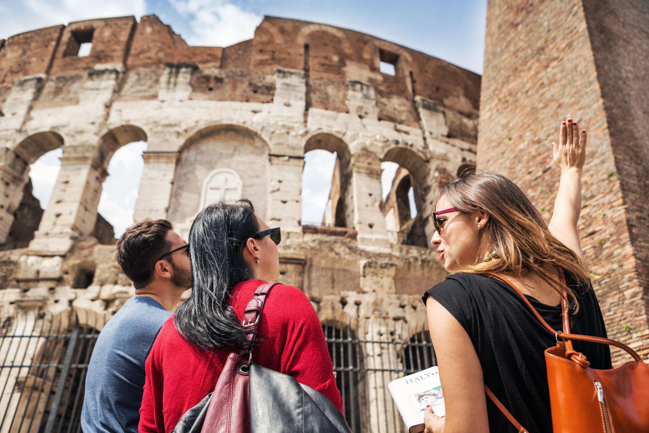 tour guide explaining something to couple at coliseum in rome