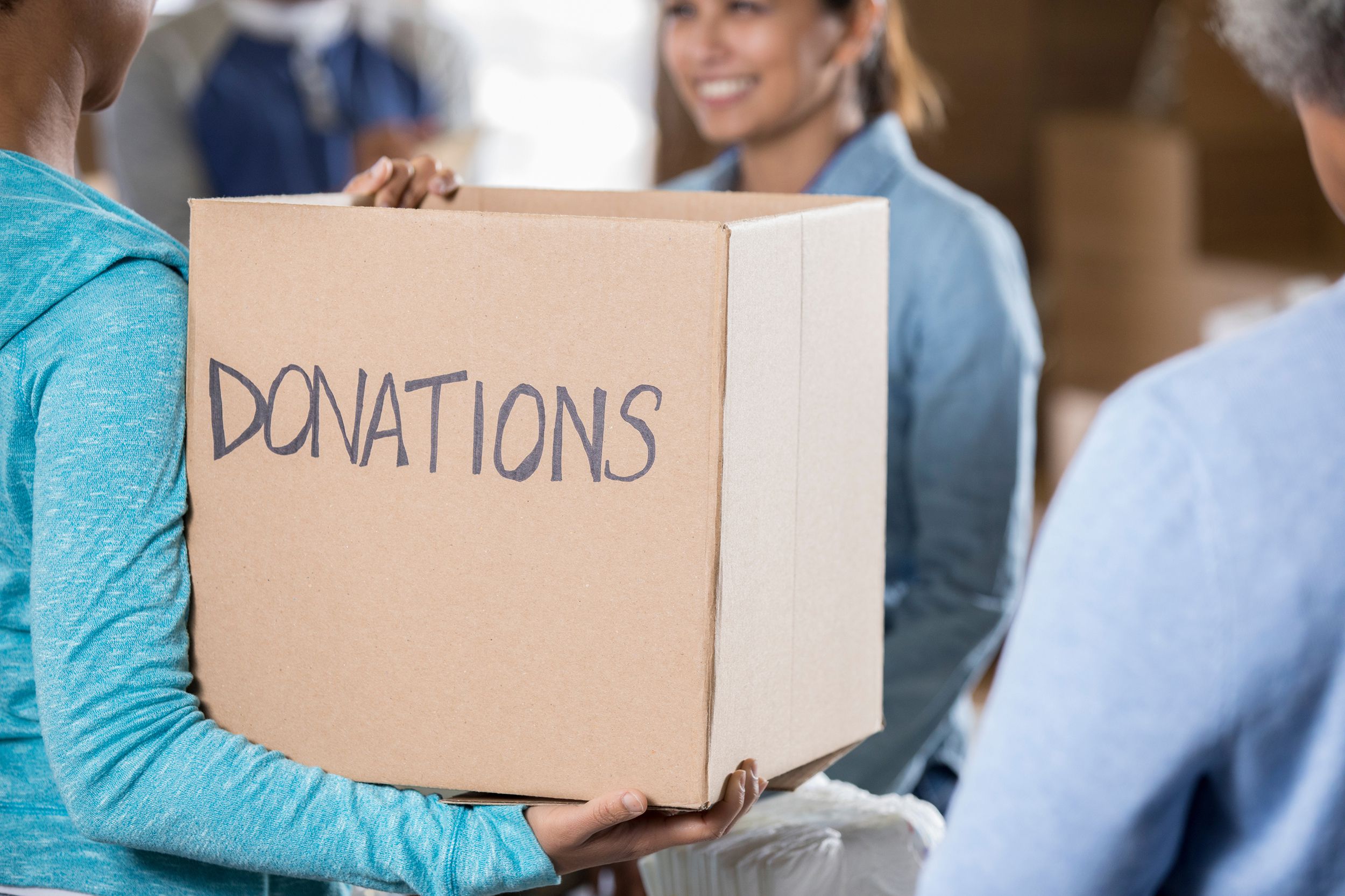 woman holds a donation box during food and clothing drive