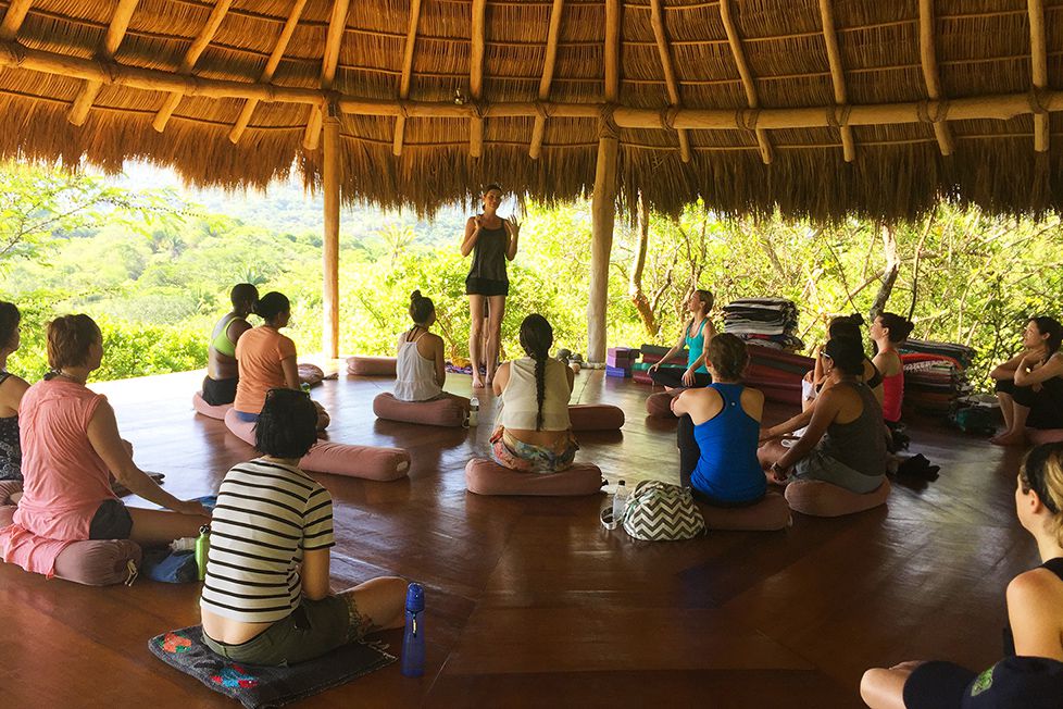 adults in meditation circle overlooking mountain