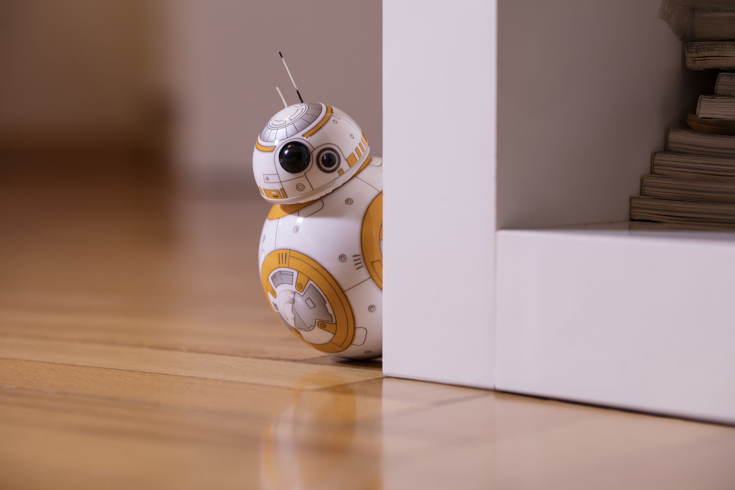 BB-8 toy hiding behind a bookshelf