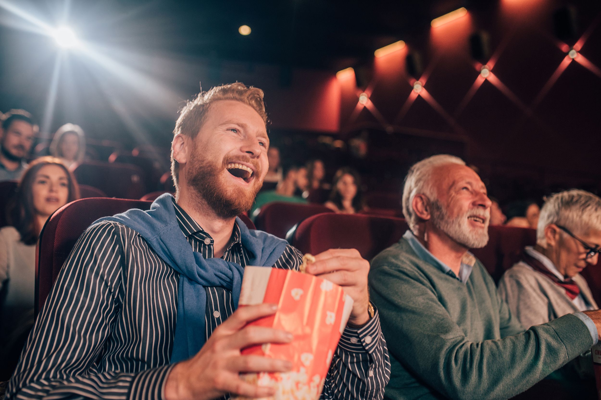 father and adult son watching movies in cinema