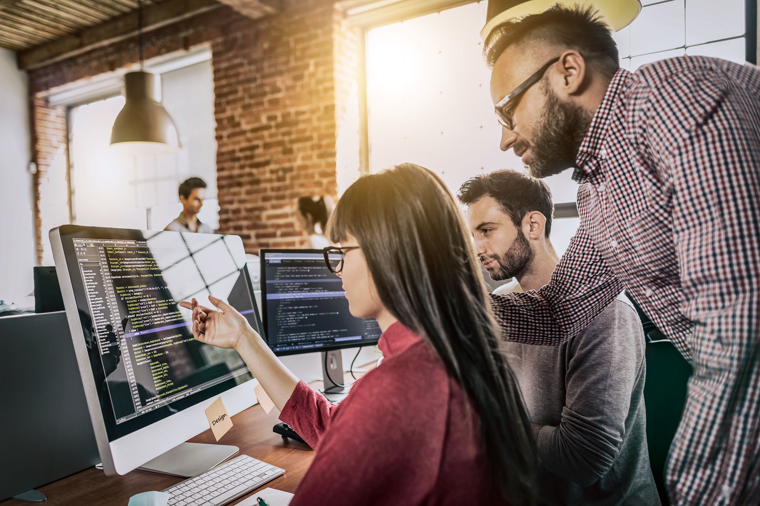 group of software developers working on computers at office