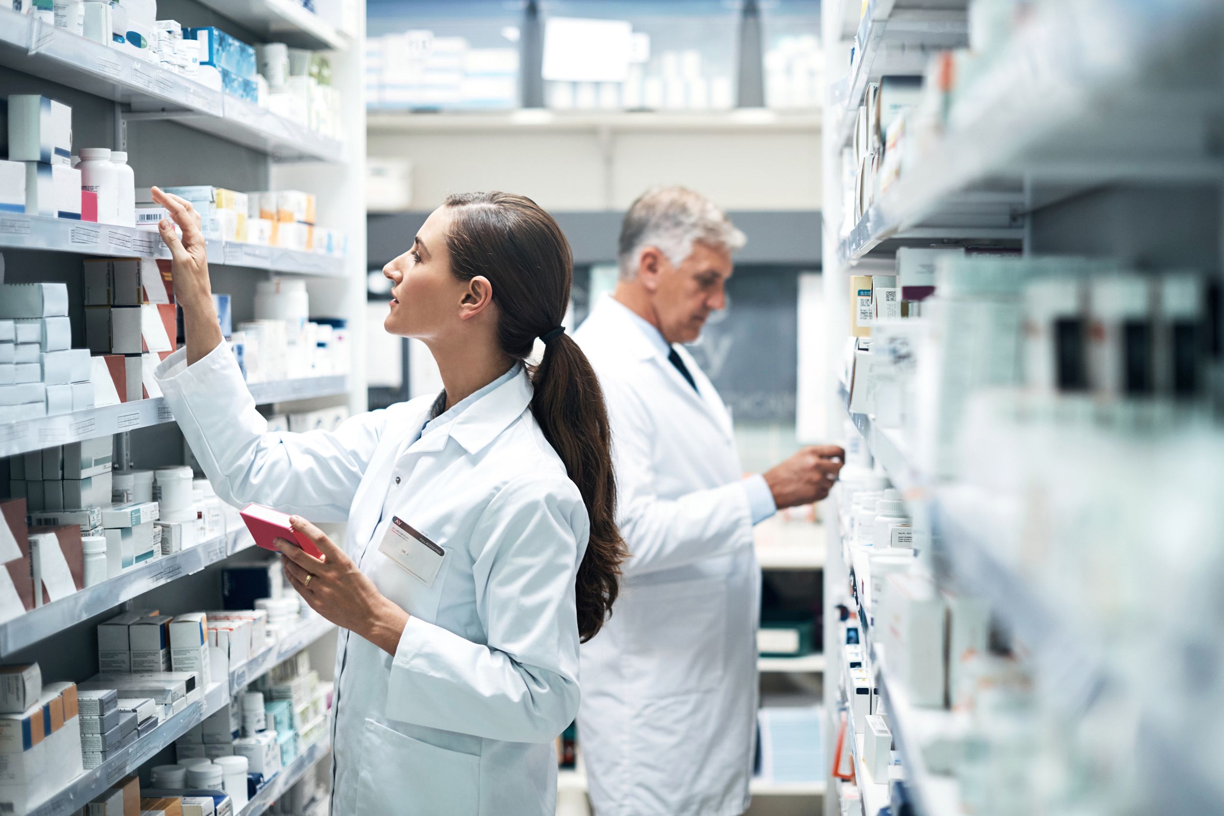 two pharmacists scouting the shelves for medications