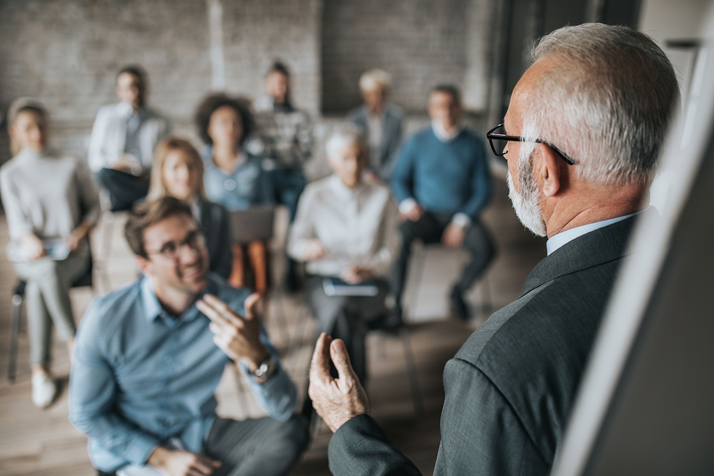 senior manager talking to large group of his colleagues on a business seminar