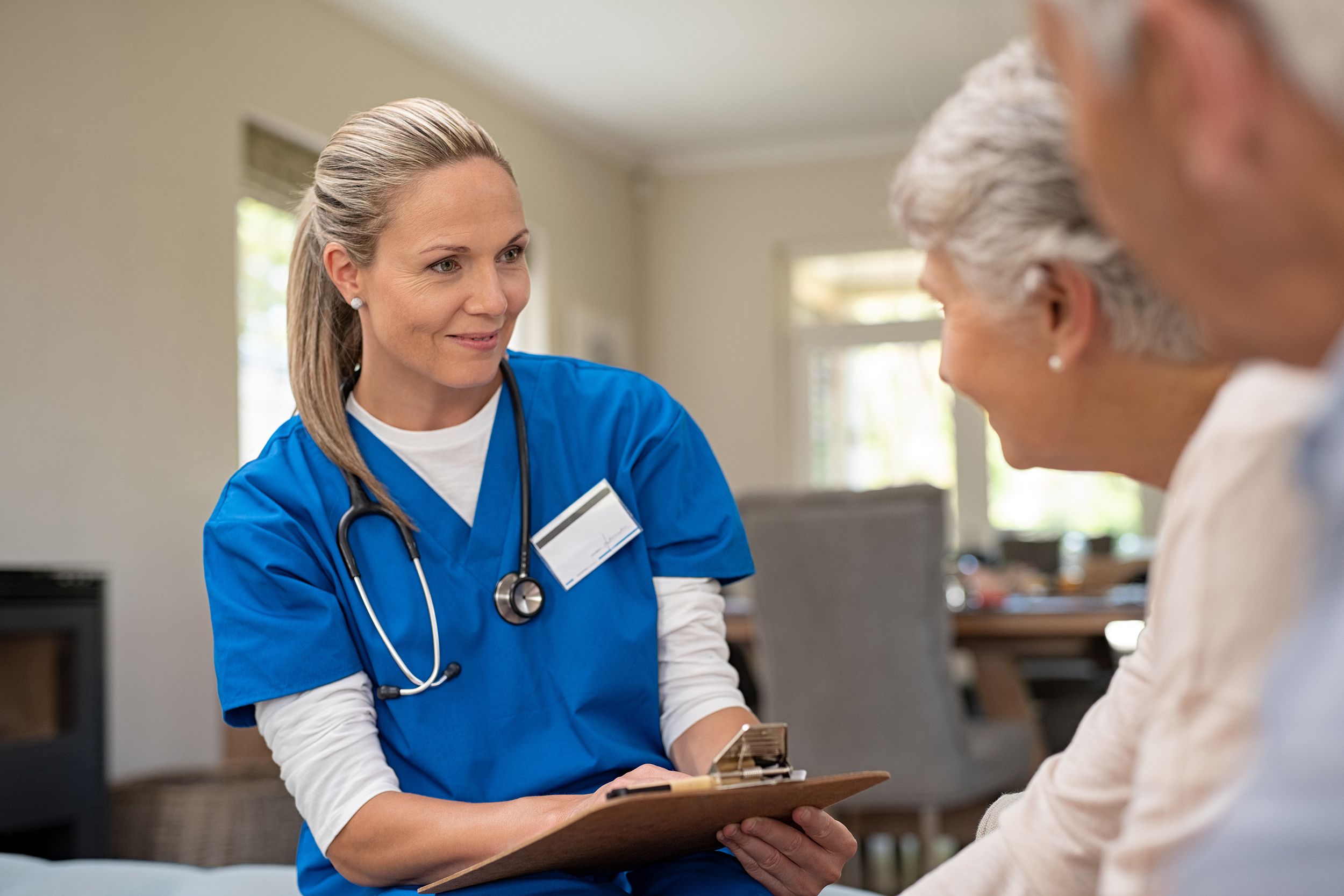 friendly nurse talking with old couple