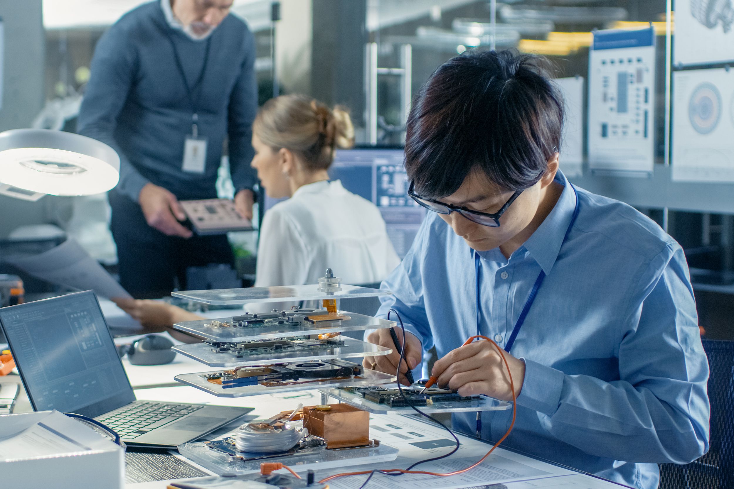 electronics engineer works with robot, soldering wires and circuits