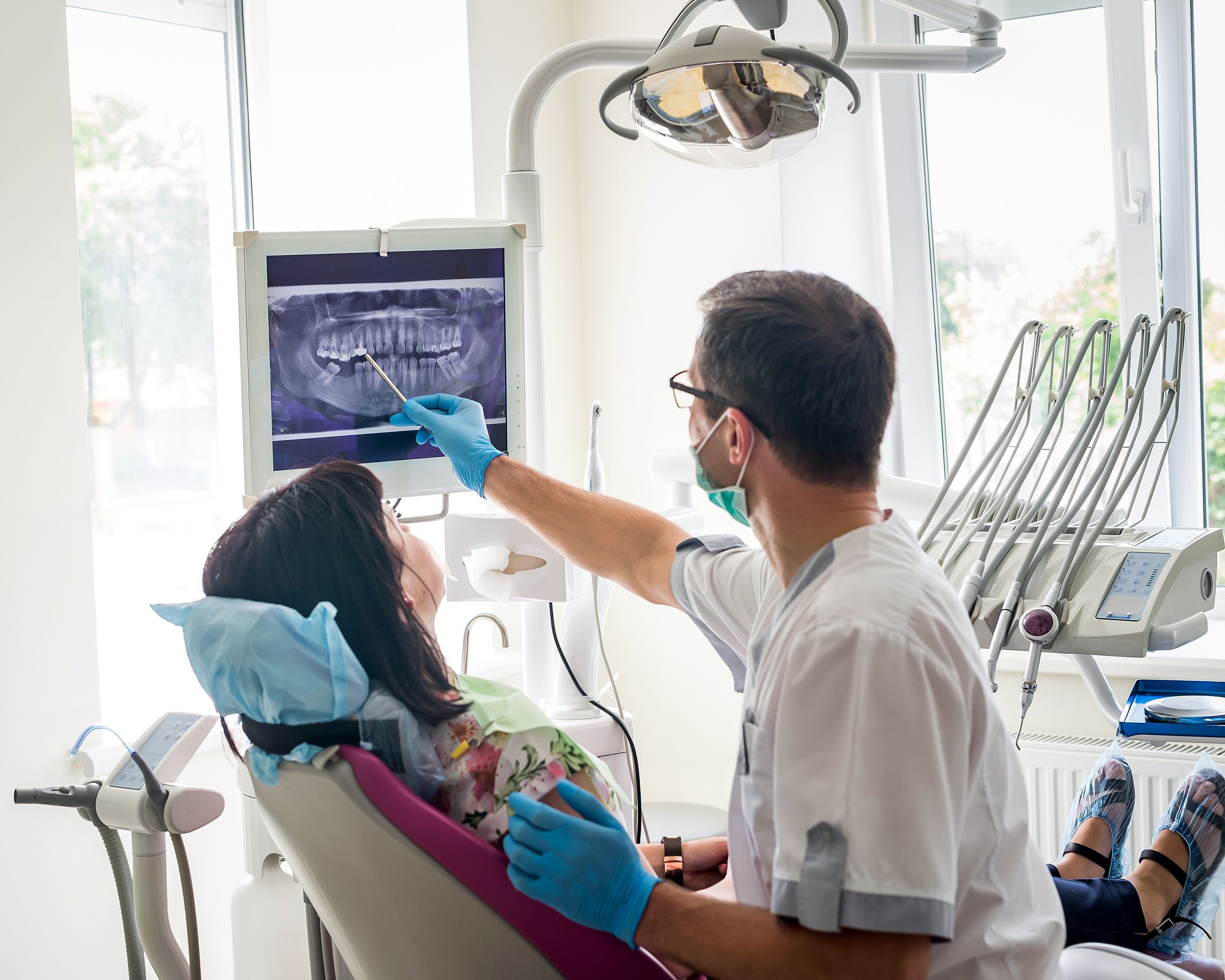 dentist showing patient's teeth on X-ray
