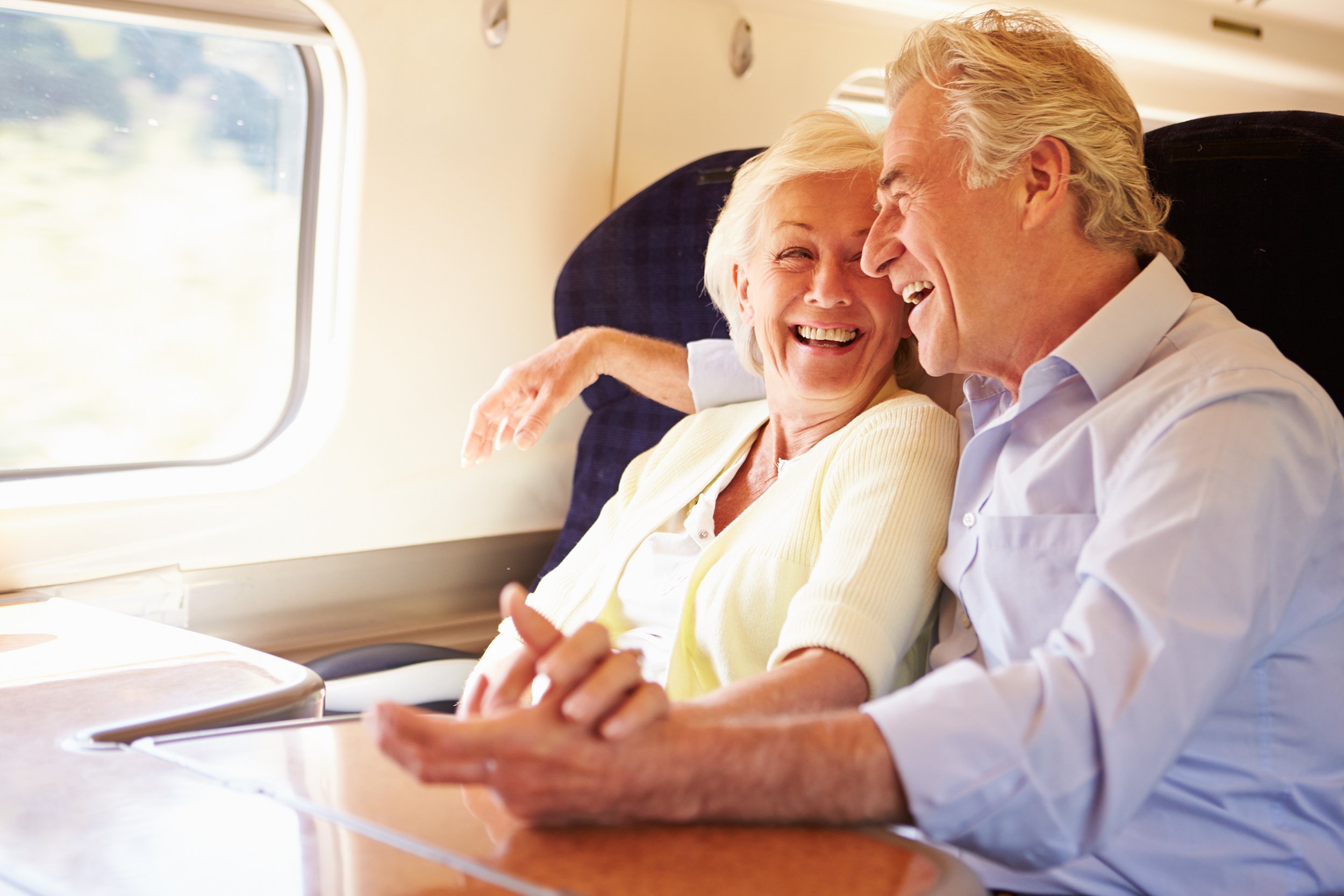 senior couple relaxing on train journey