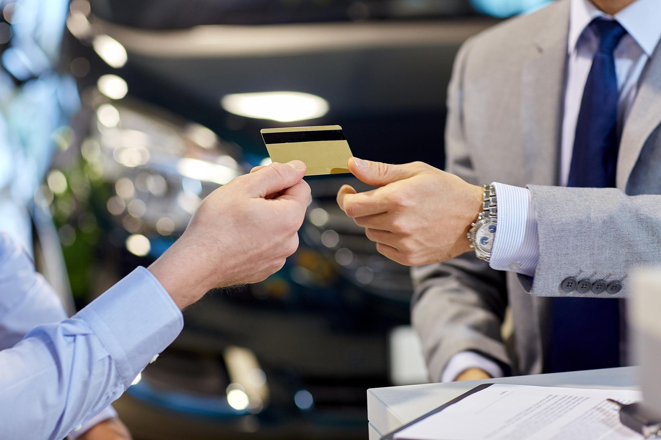 close up of customer giving credit card to rental car person