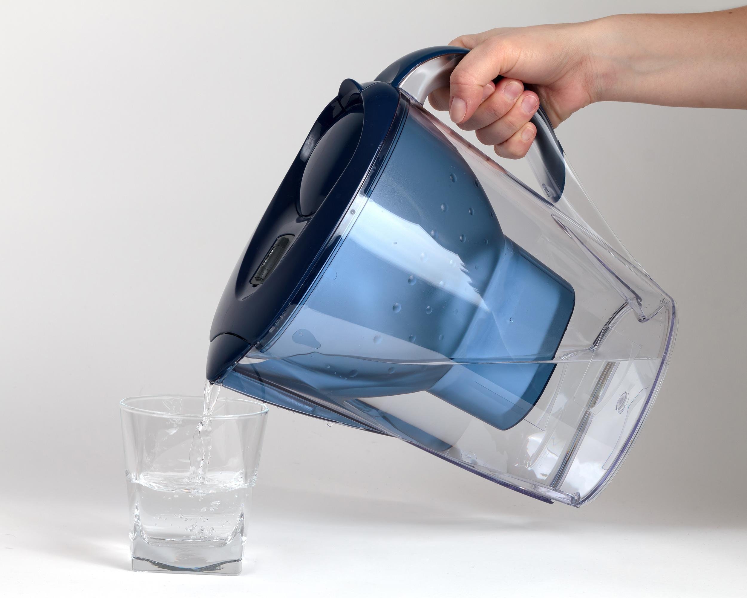 pouring water from water filter into glass