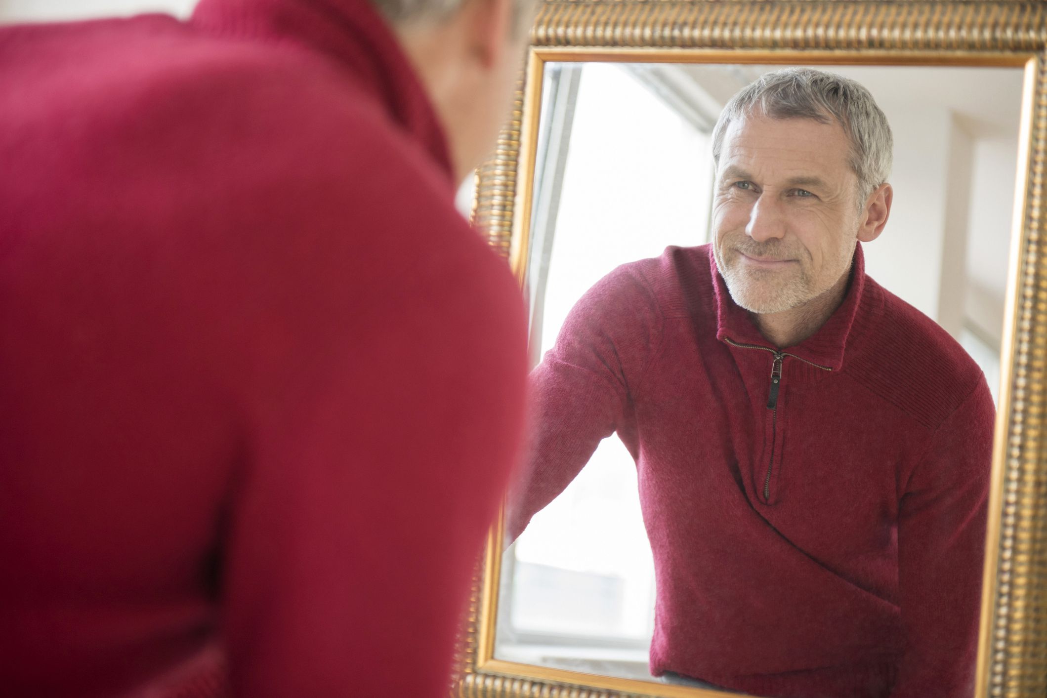 smiling man looking in mirror