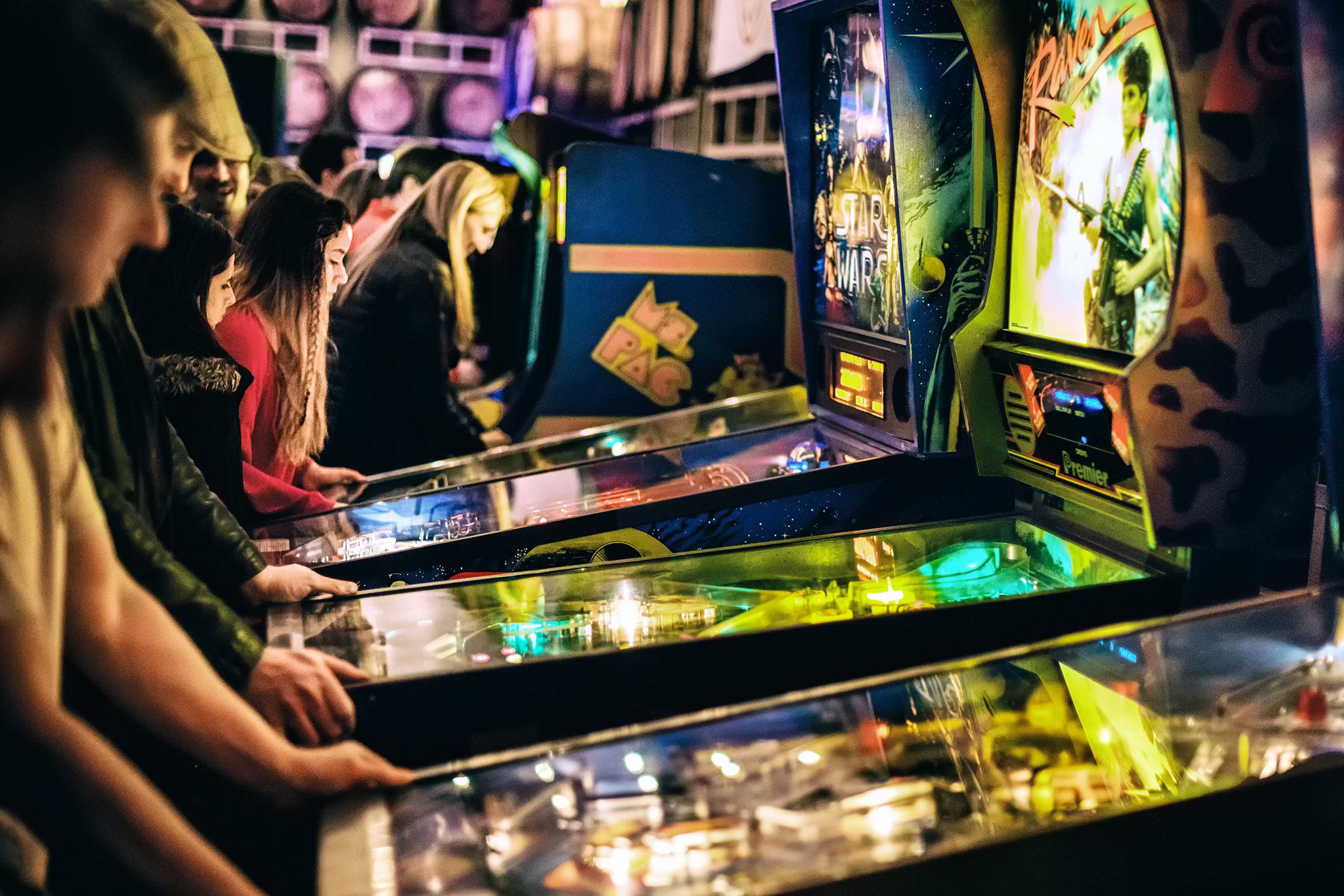 People playing pinball machines