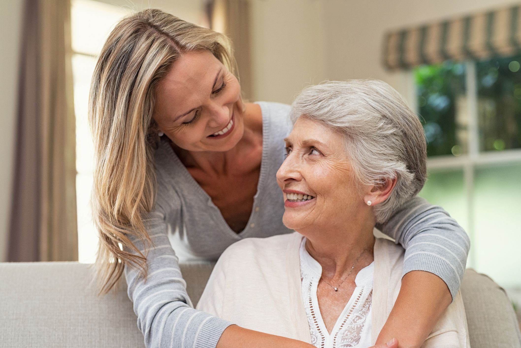middle-aged woman embracing senior mother