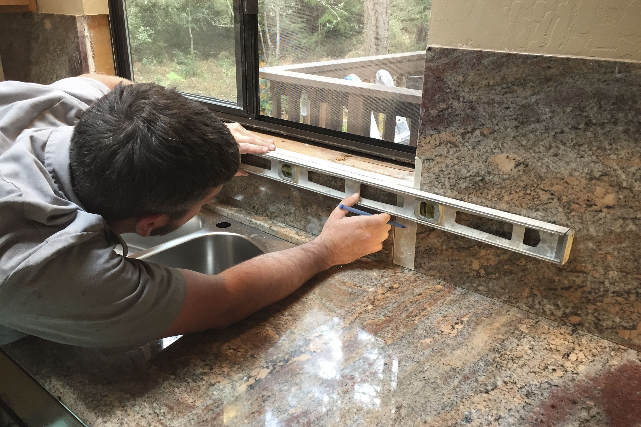 man measuring area to put in kitchen countertop