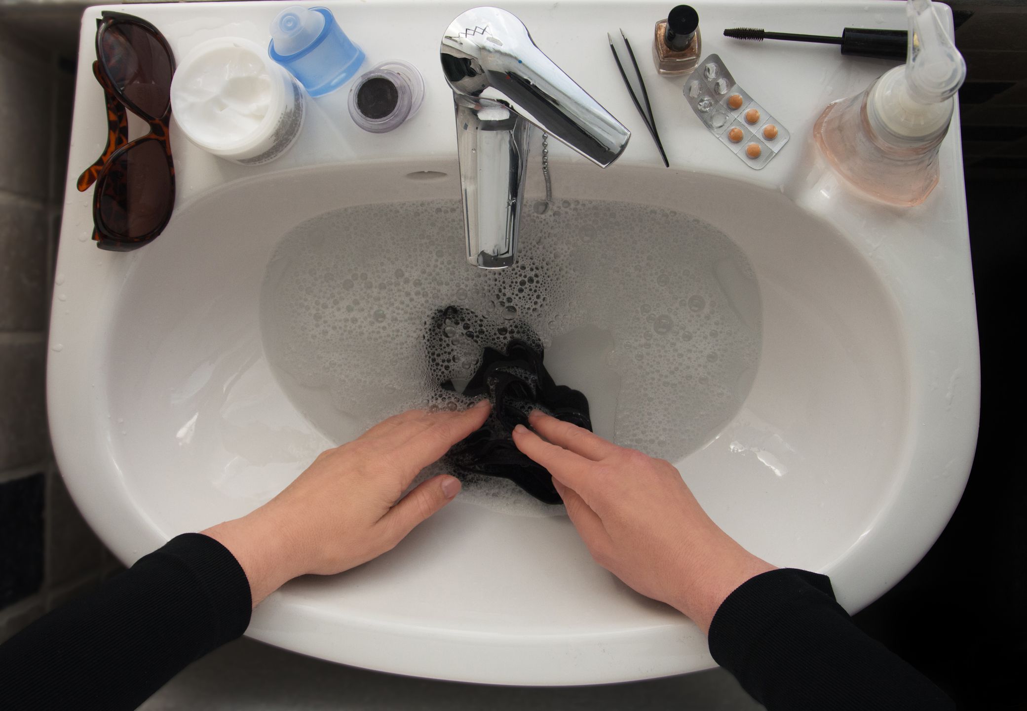 handwashing clothes in sink