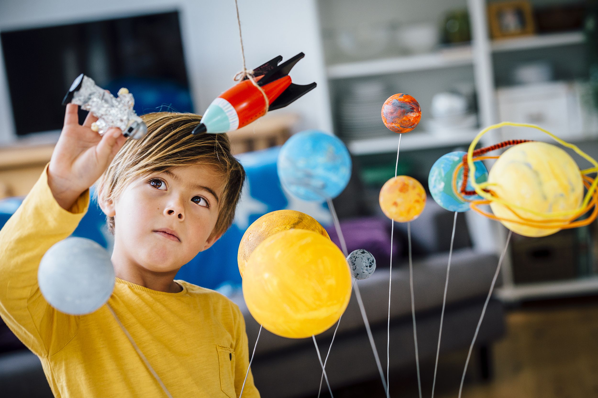 little boy playing with planet model