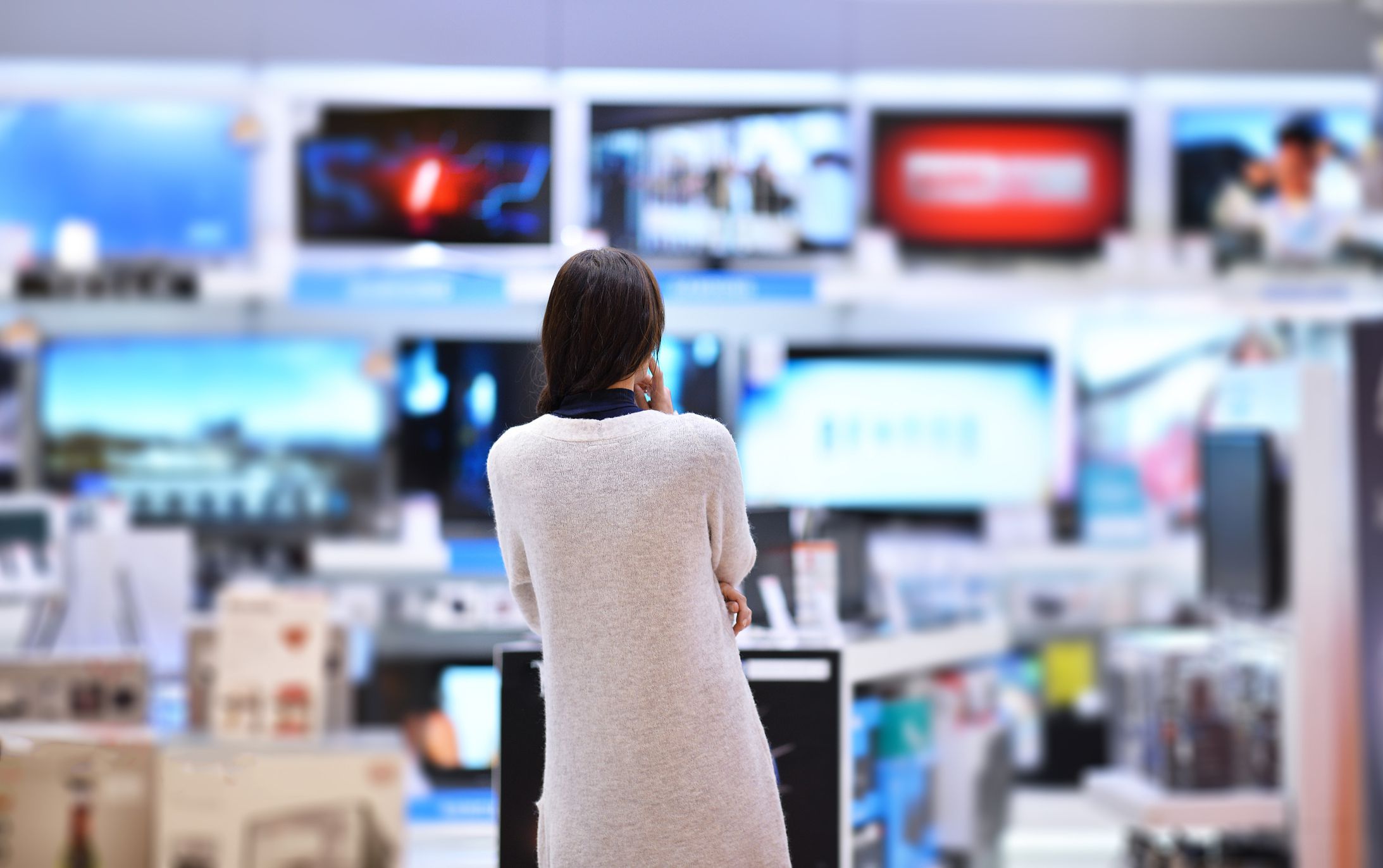 woman looking at tvs in store