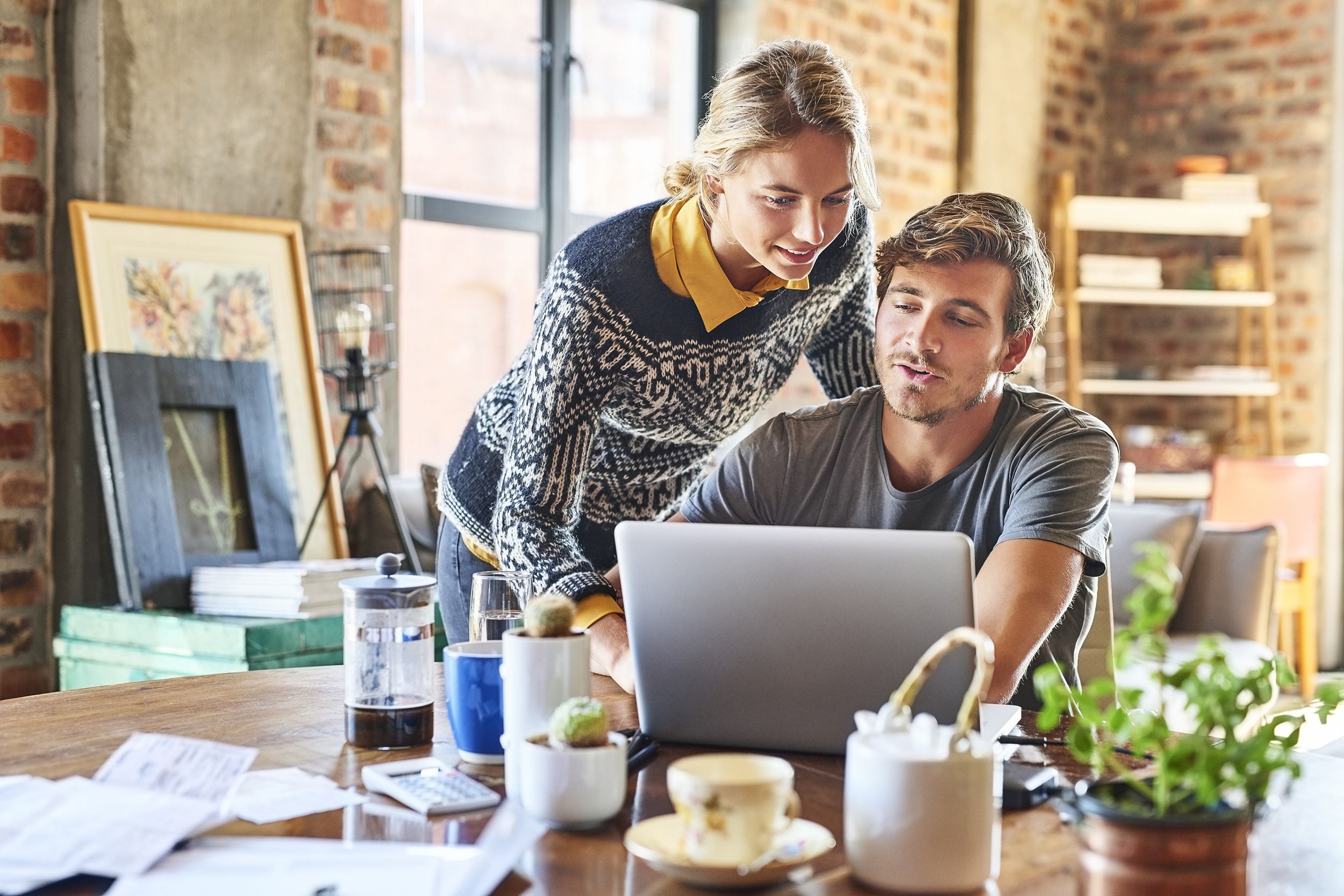 young couple discussing while using laptop at home