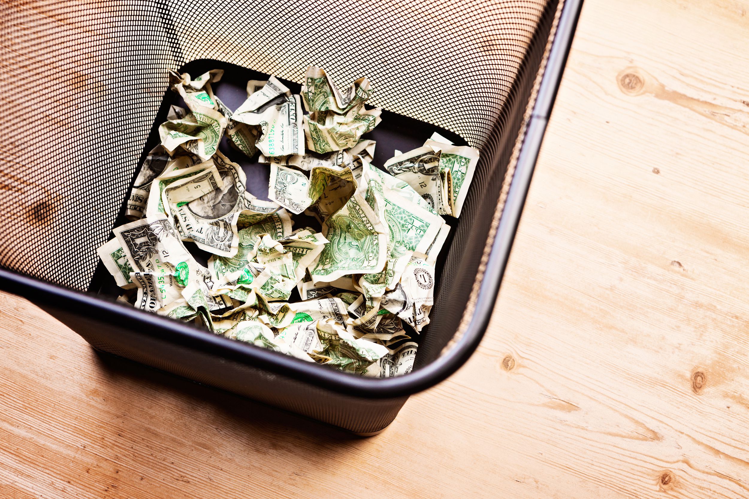 looking into wastepaper basket holding trashed banknotes