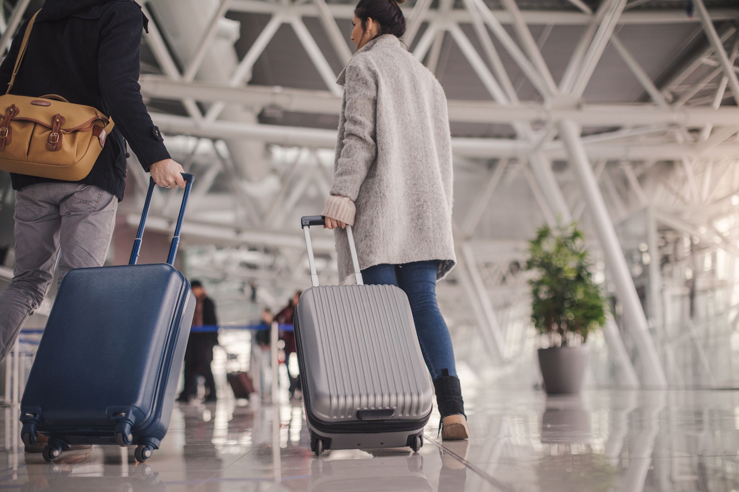 young couple arriving at the airport with luggage
