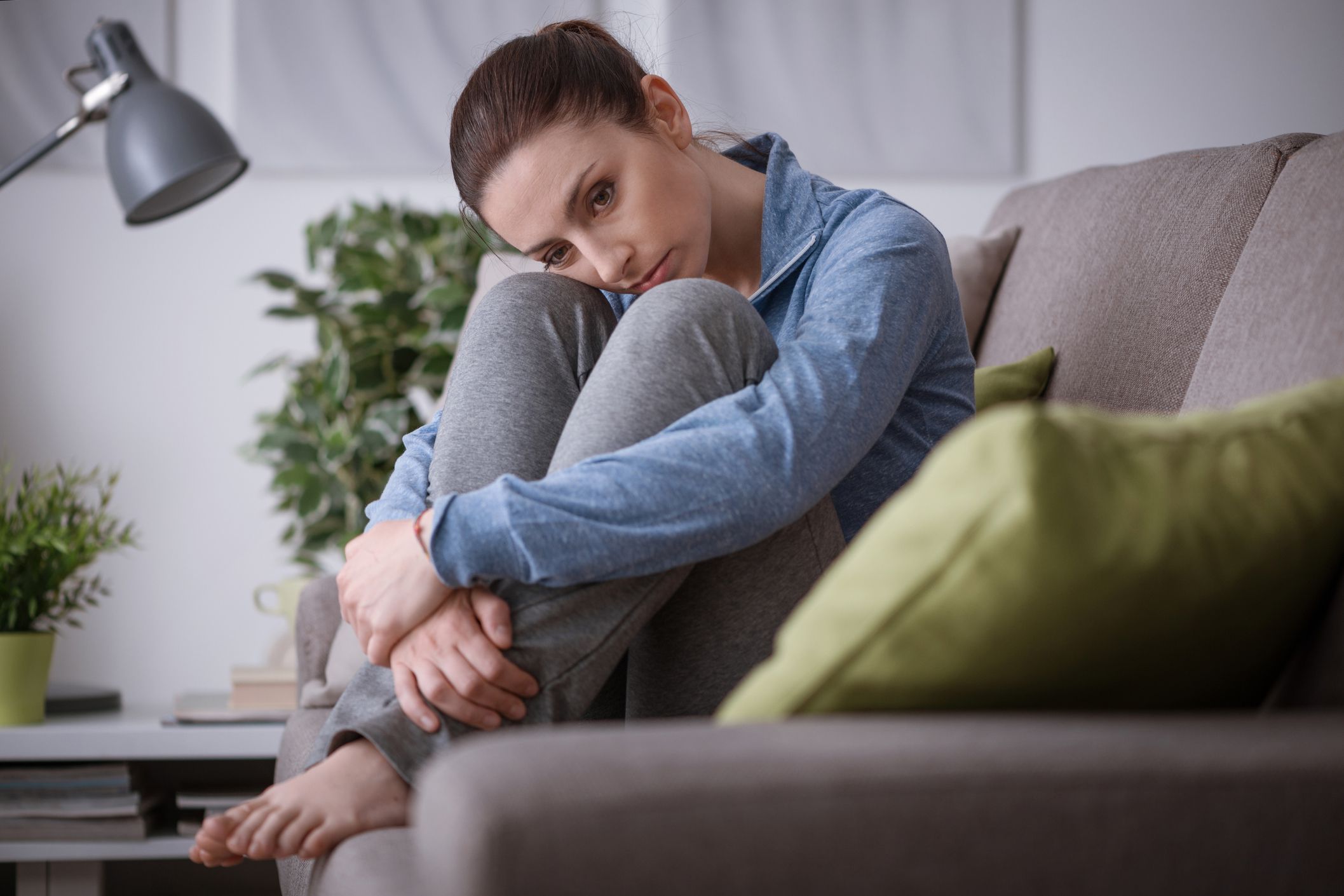 sad, tired woman on couch