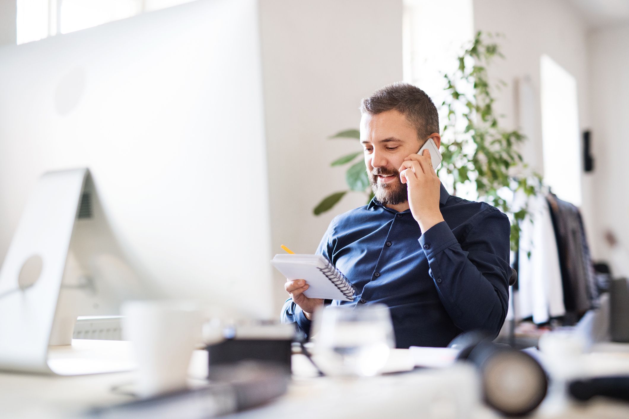 man looking at agenda speaking on phone