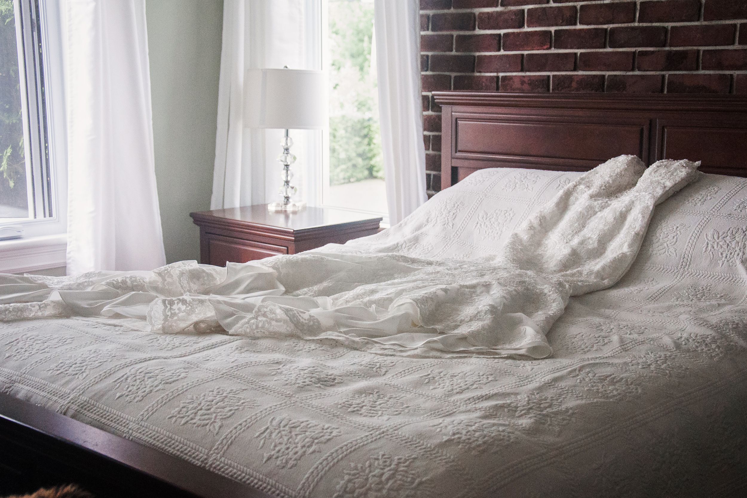 wedding dress on a bed