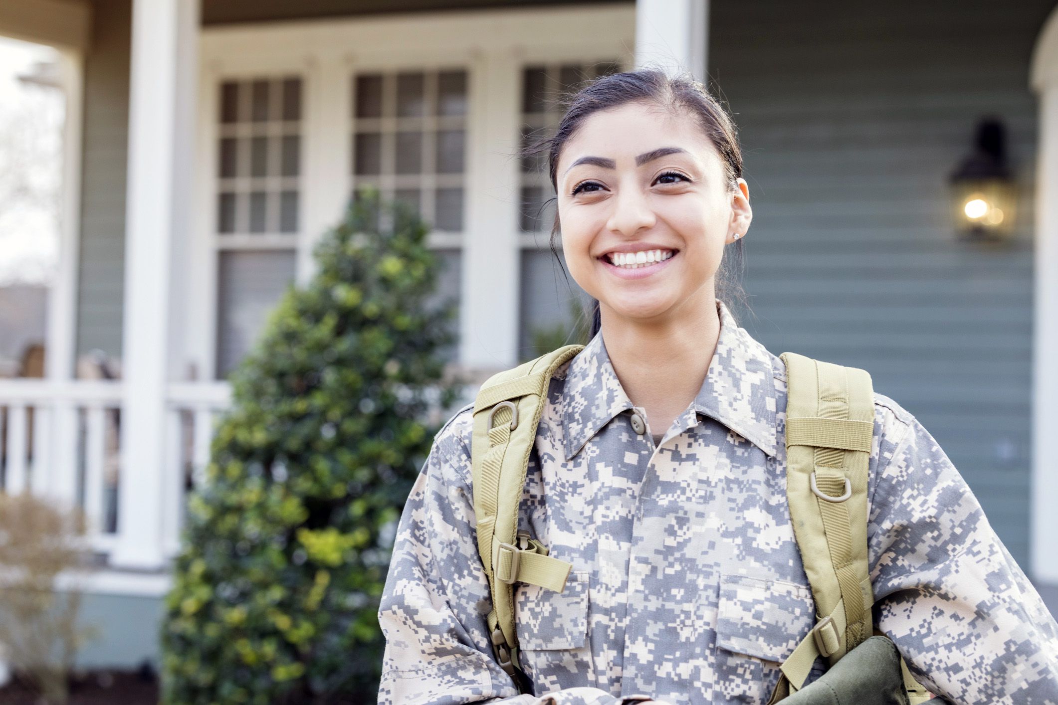 smiling soldier in front of house