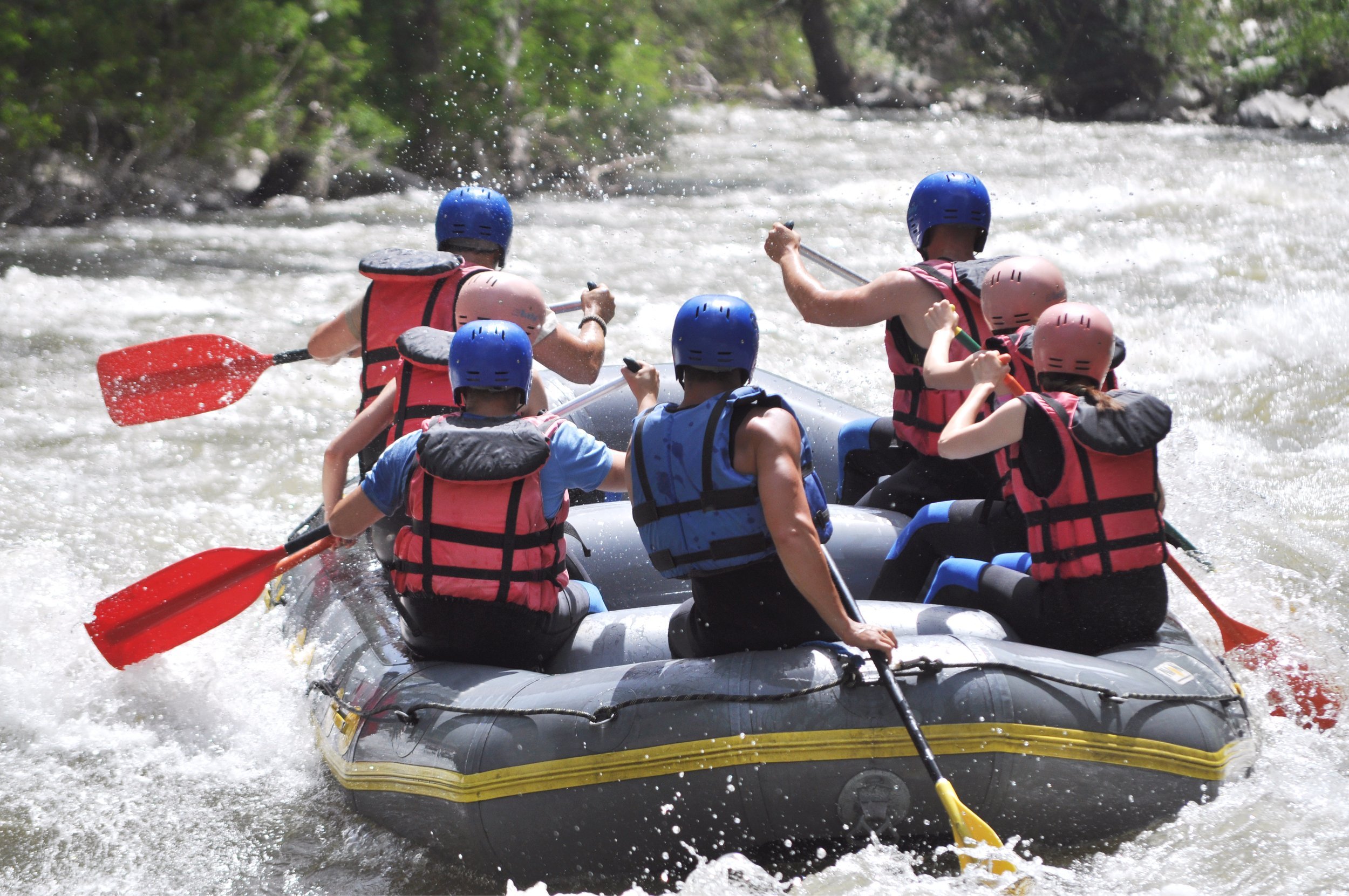 group of people whitewater rafting.