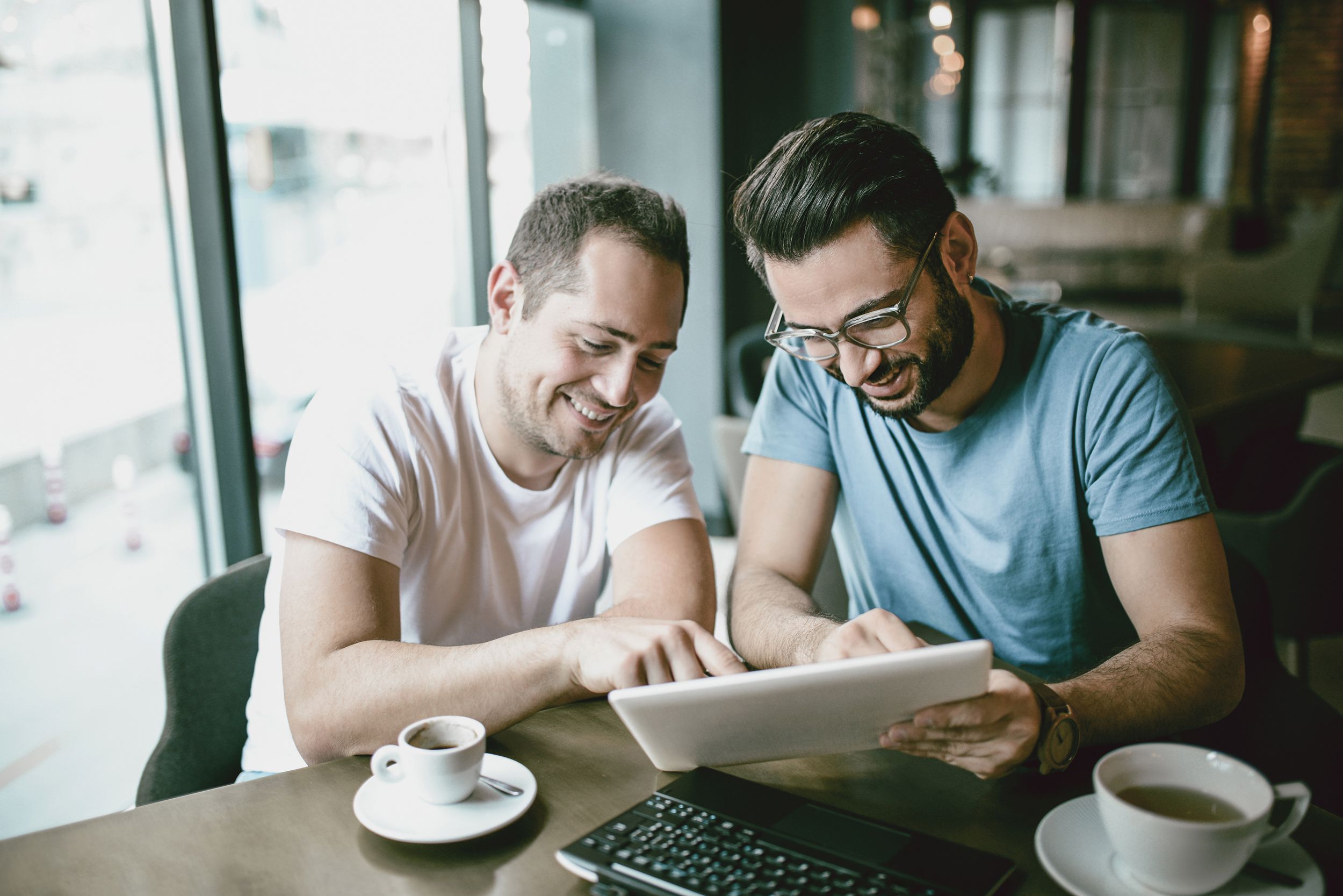 couple at coffee shop looking at laptop