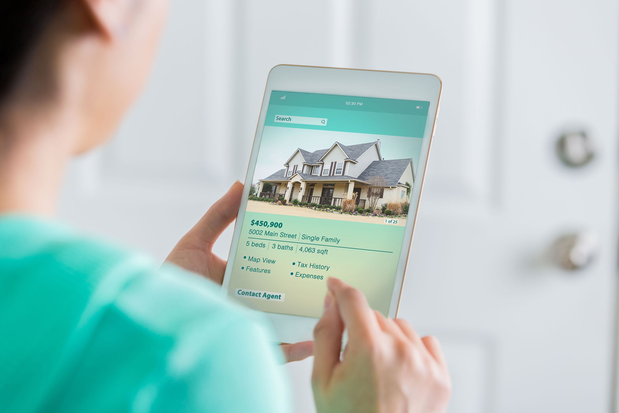 woman uses digital table to search for new home