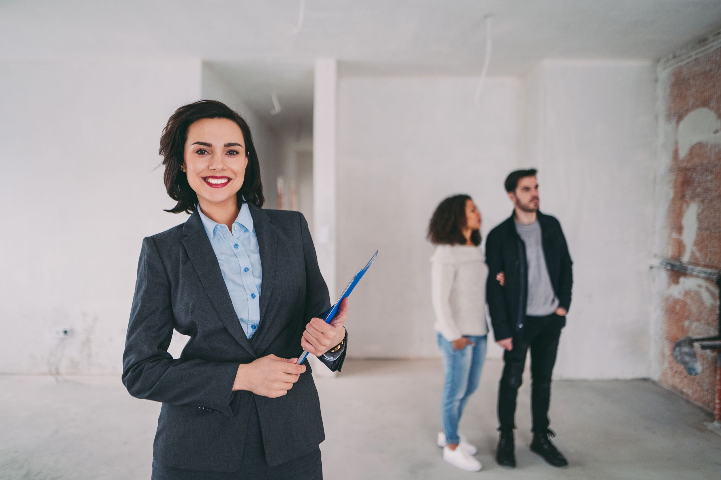 real estate agent showing new home to clients