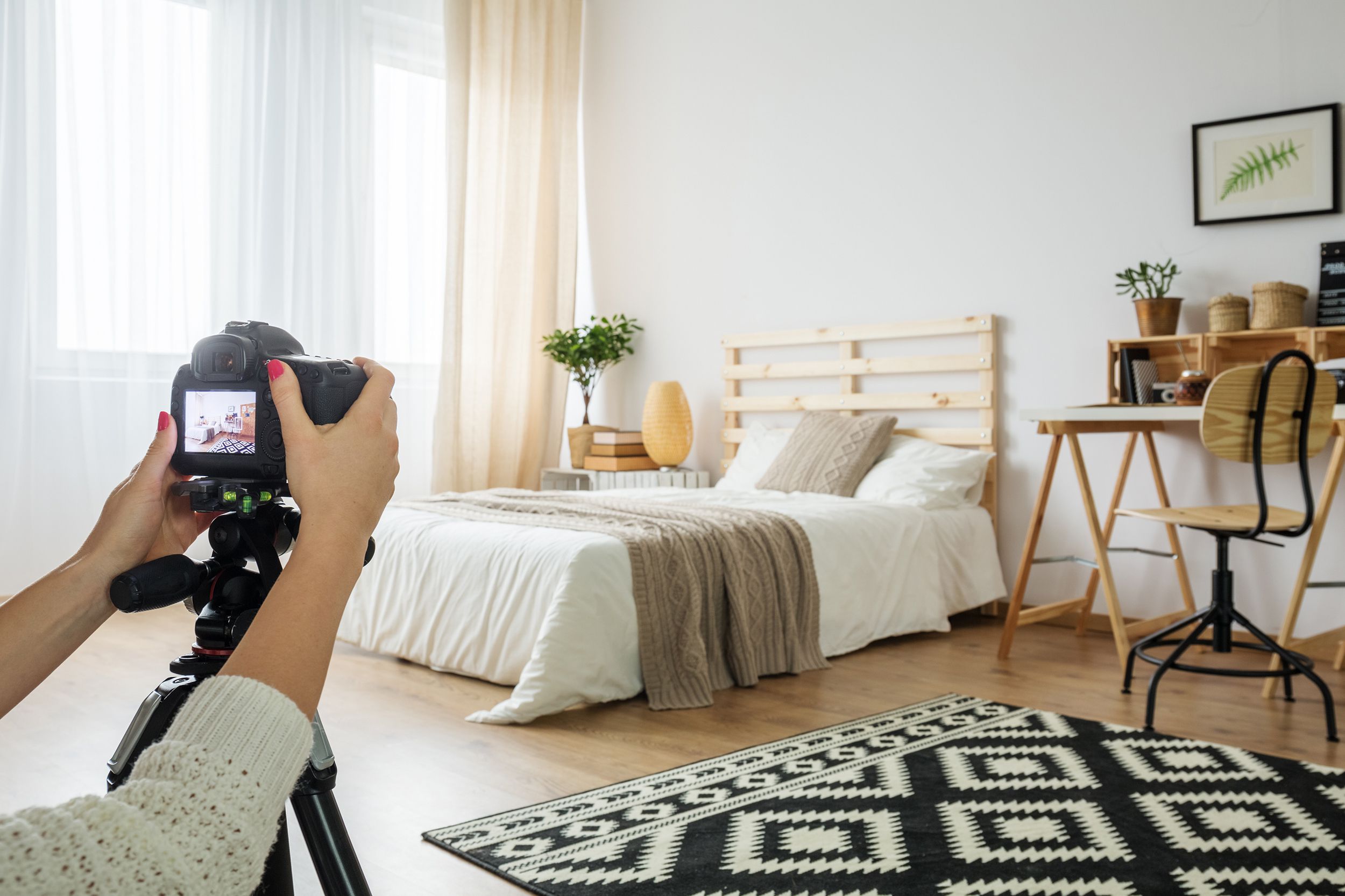 person taking picture of bedroom with camera