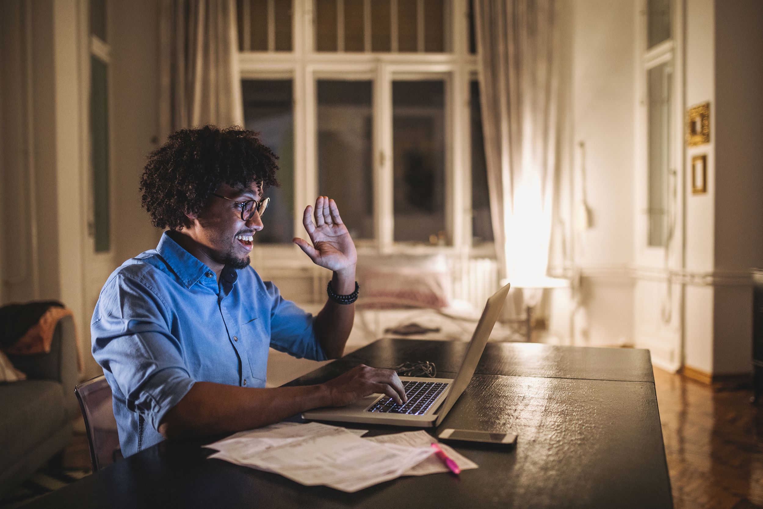cheerful student talking over a laptop computer with his friends