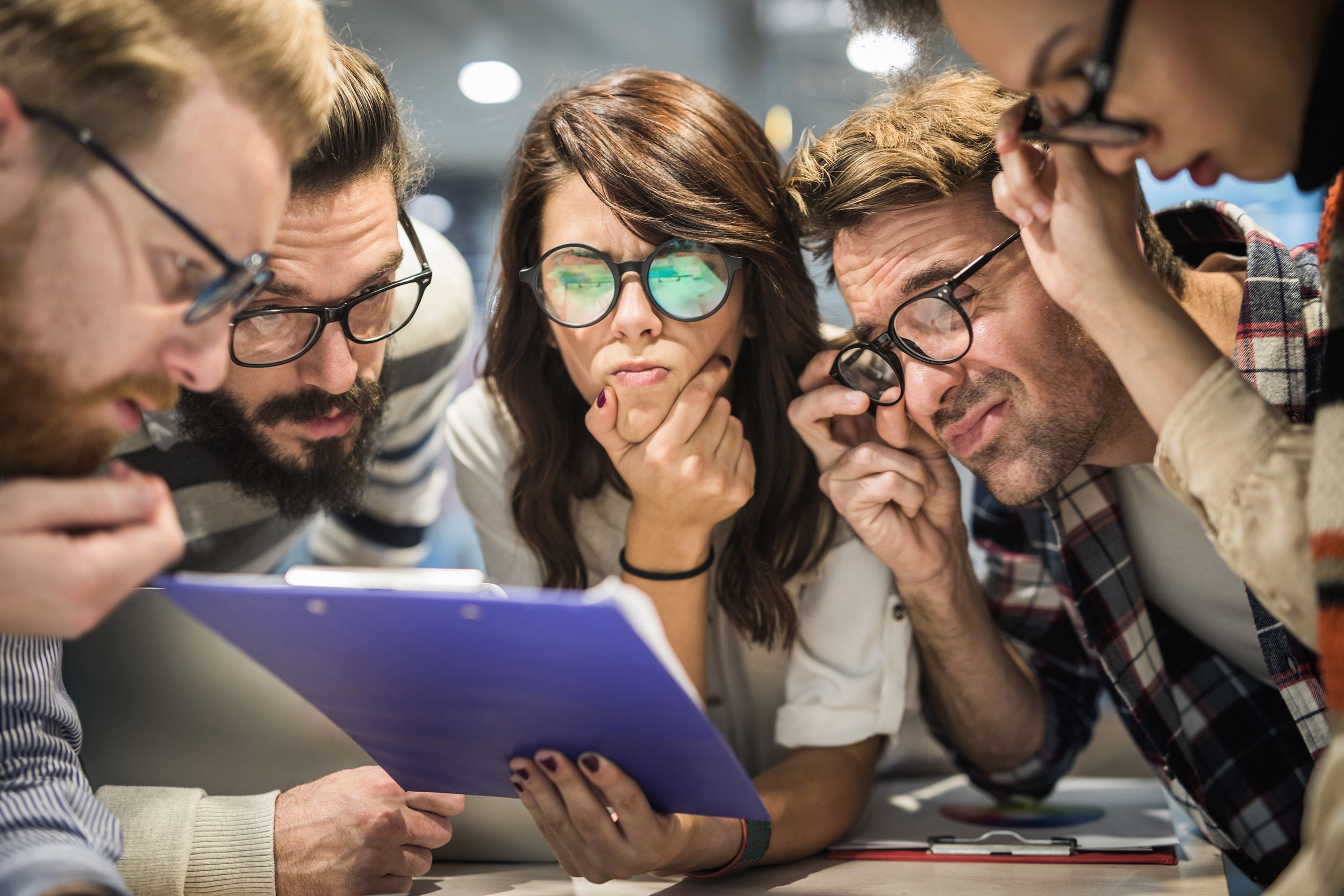 team of nerdy entrepreneurs reading confusing reports in the office