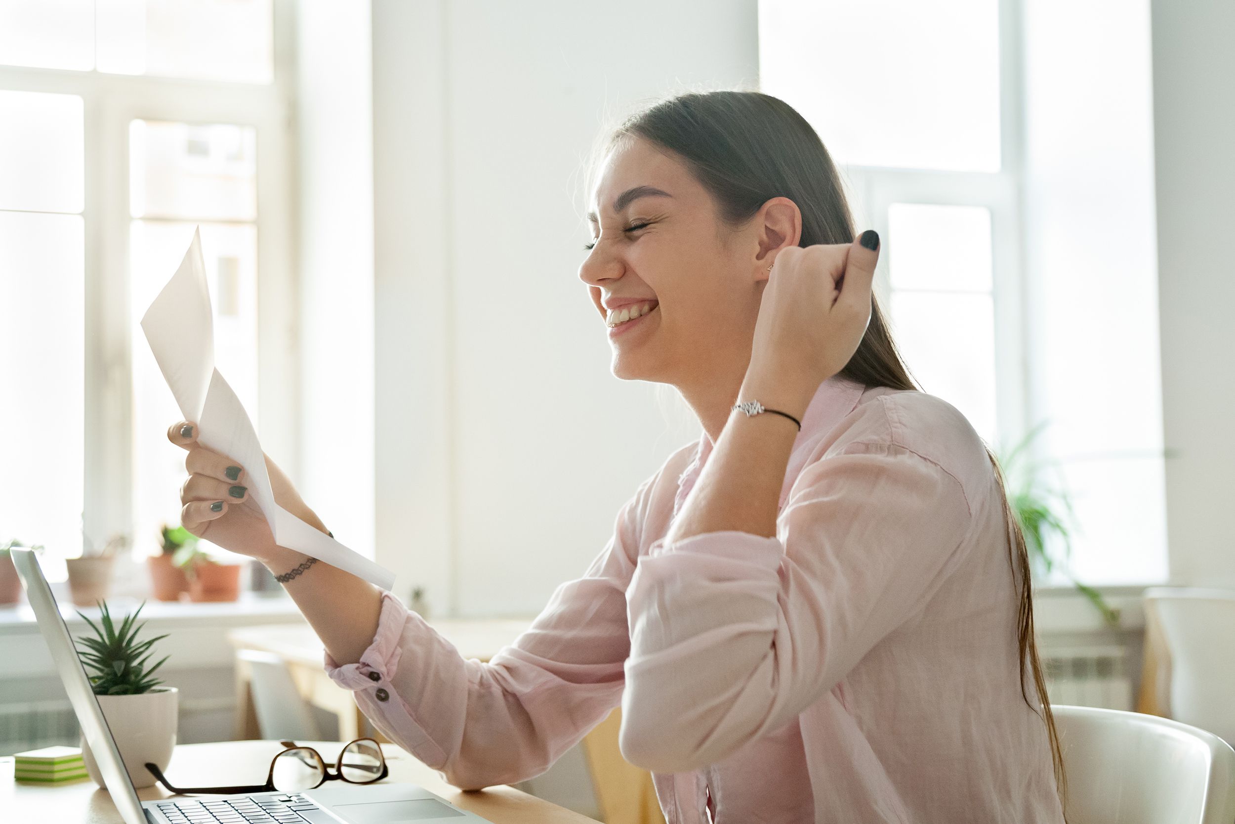happy female employee excited reading promotion letter