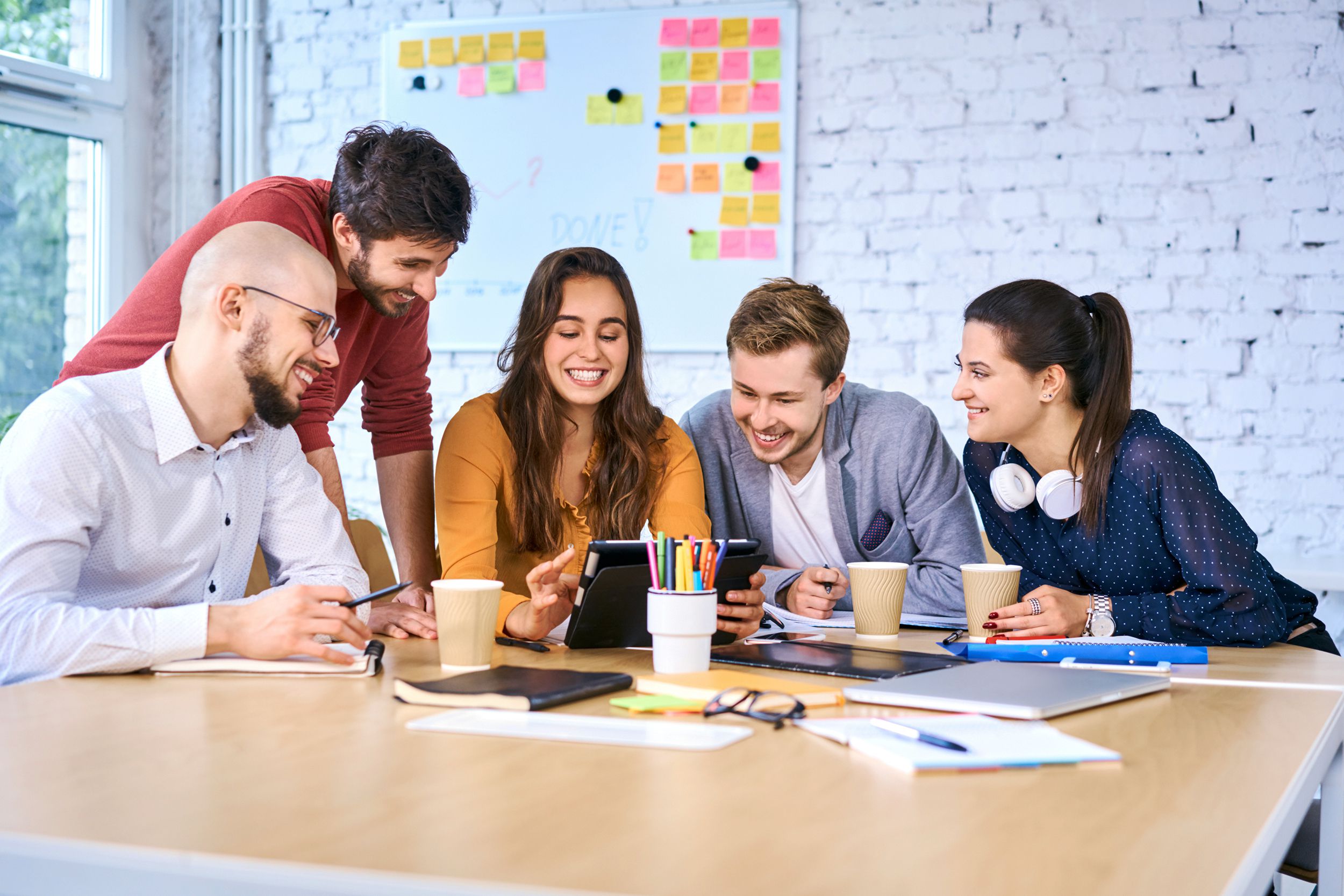 young startup businesspeople looking tablet during brainstorming meeting