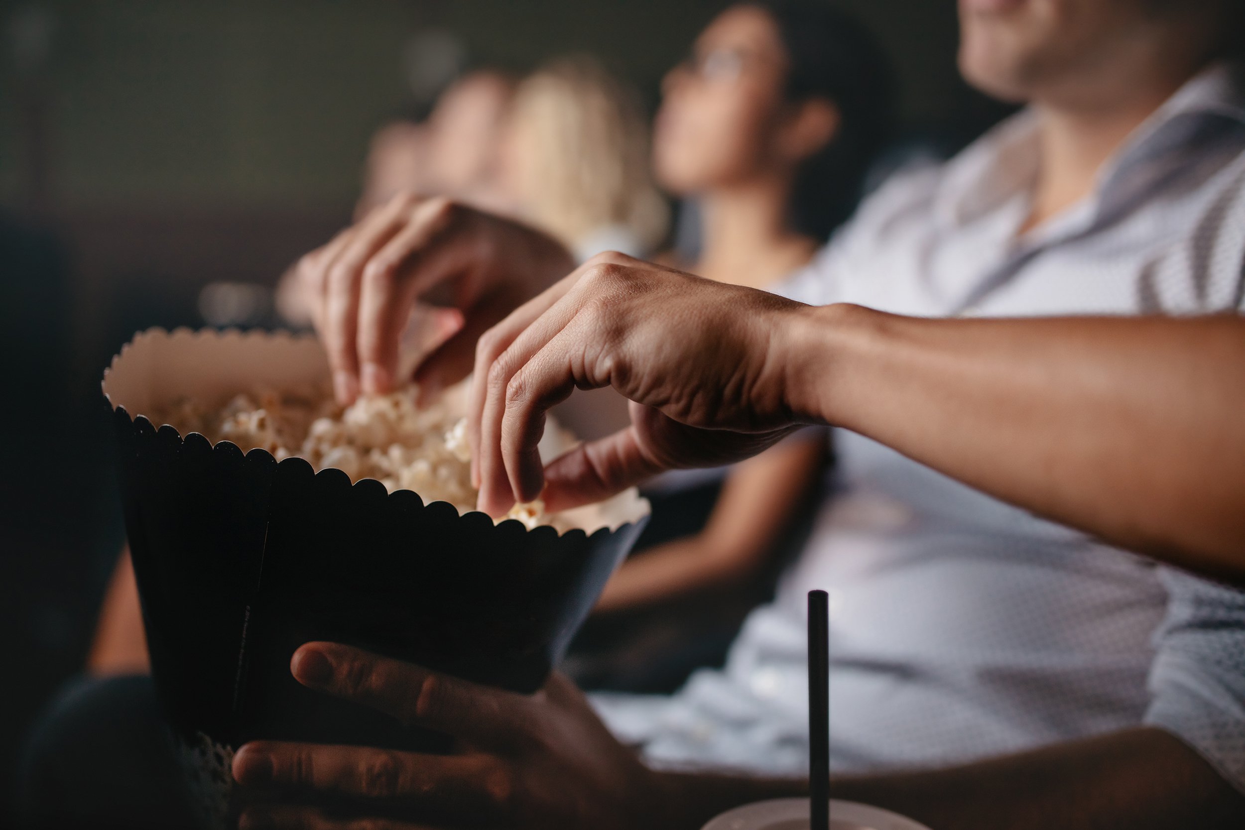 people eating popcorn in movie theater
