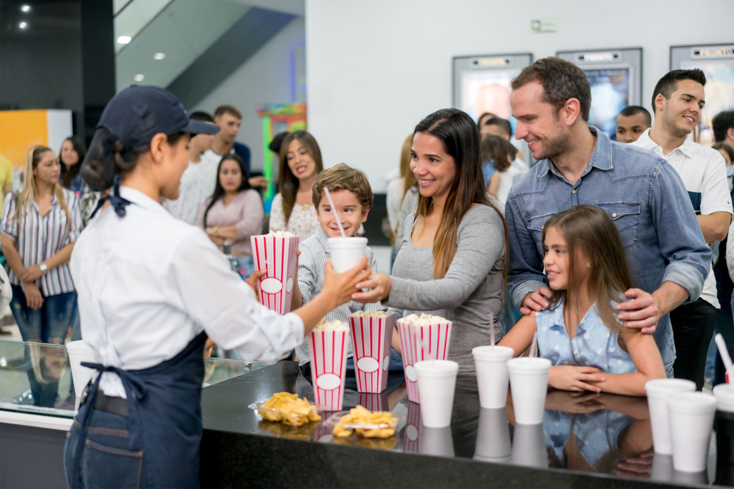 Family getting snacks at the movie theater concession stand