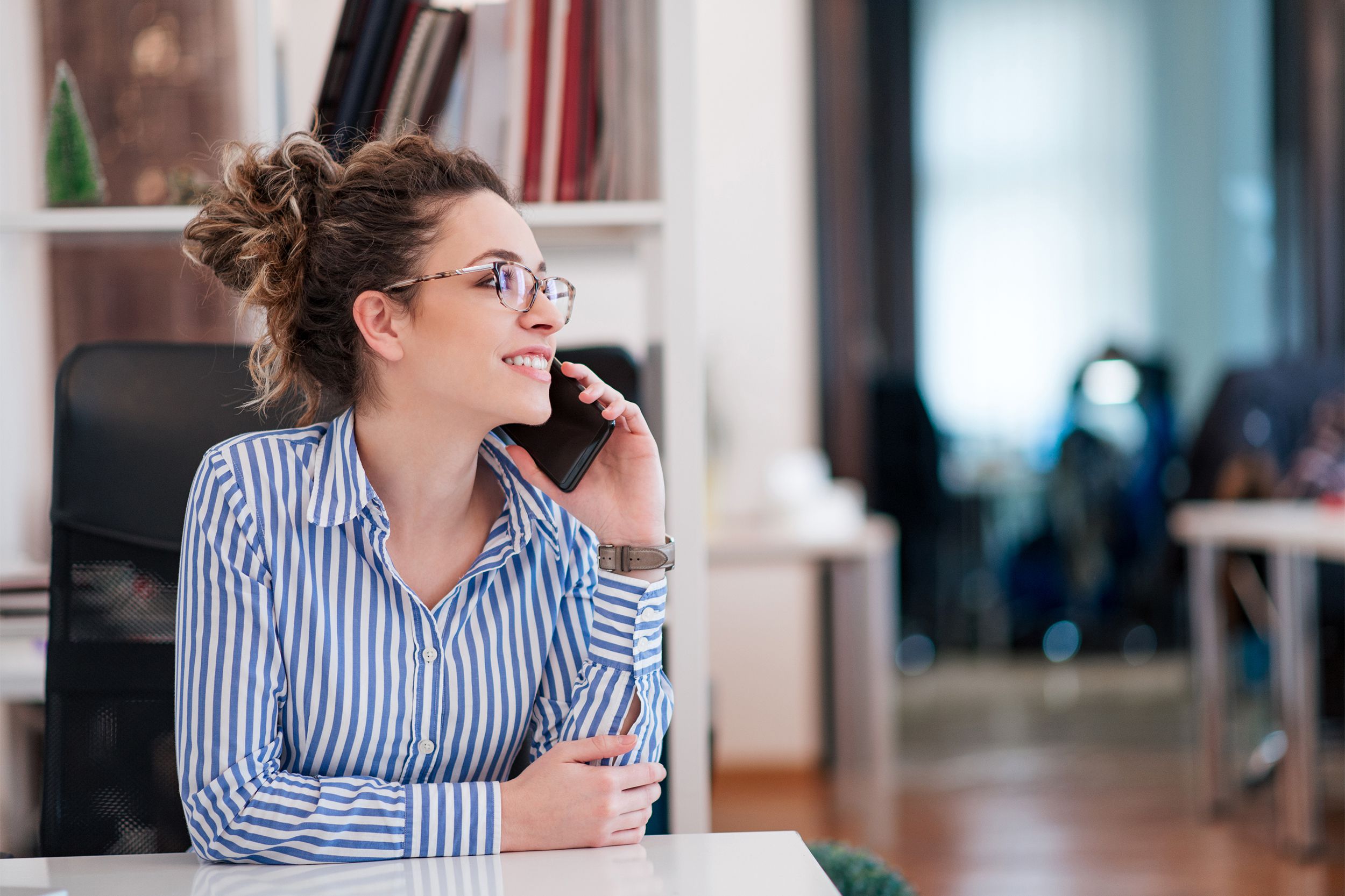 Young woman talking on the phone in an office
