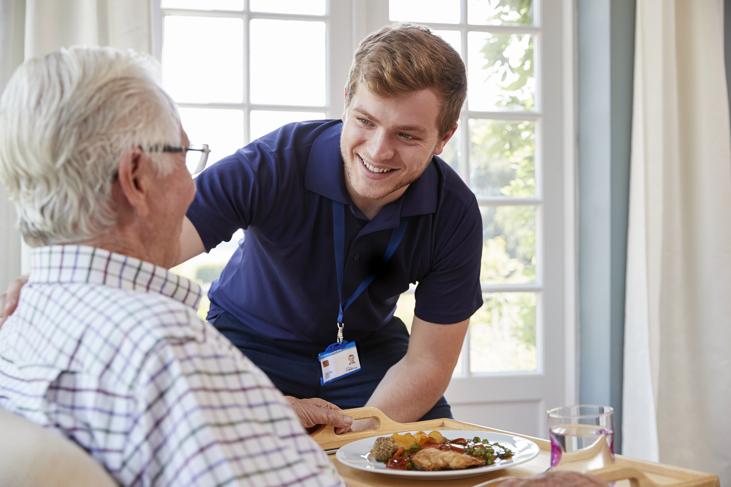 Young man assisting a senior man at a nursing home