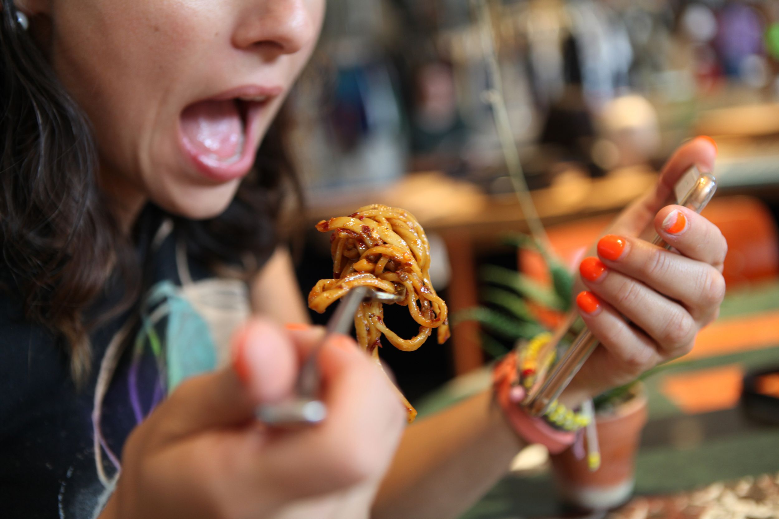 woman eating some pasta in the terrace of a restaurant