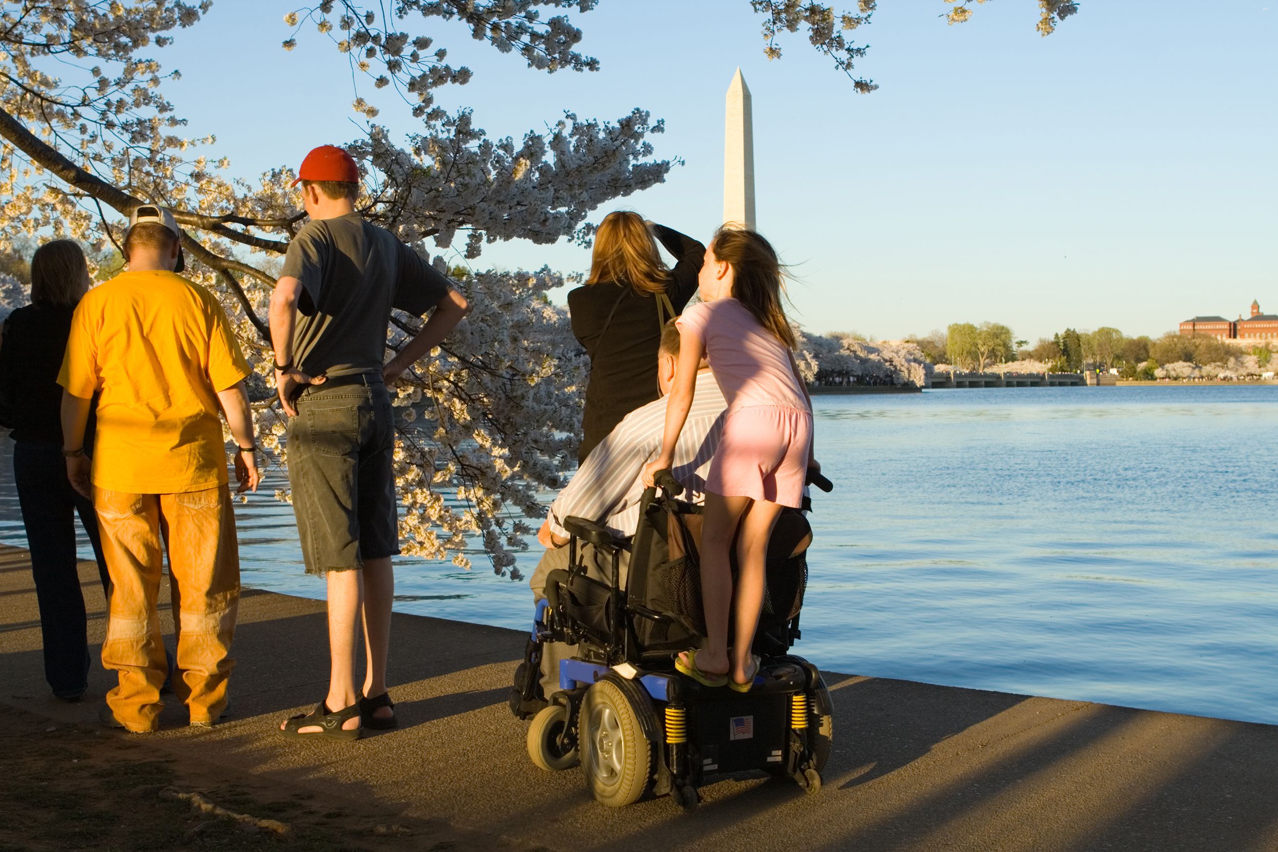 man motorized wheelchair with granddaughter riding along Washington D.C.