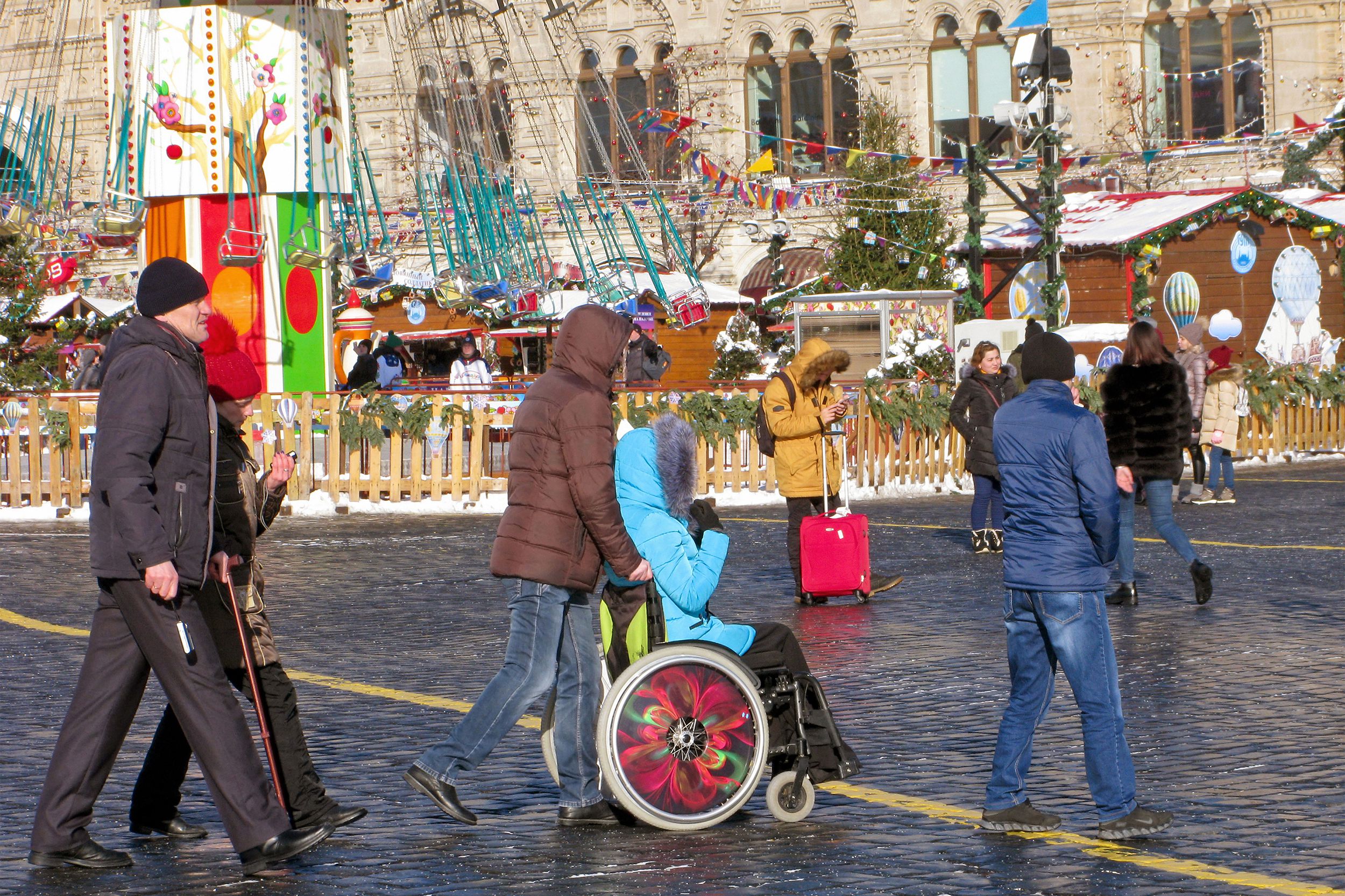 wheelchair person and others in street during Christmas winterfest