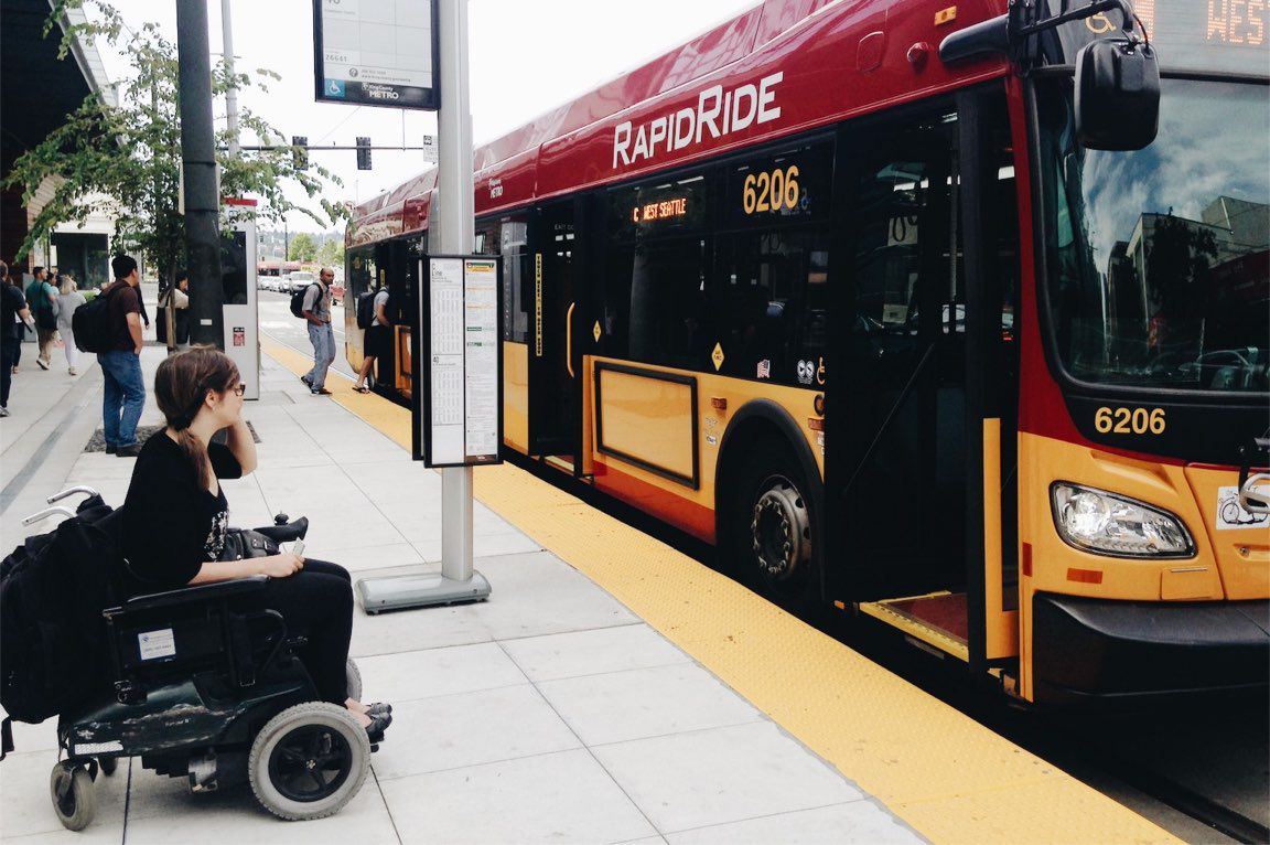 wheelchair user waits to board Rapid Ride bus