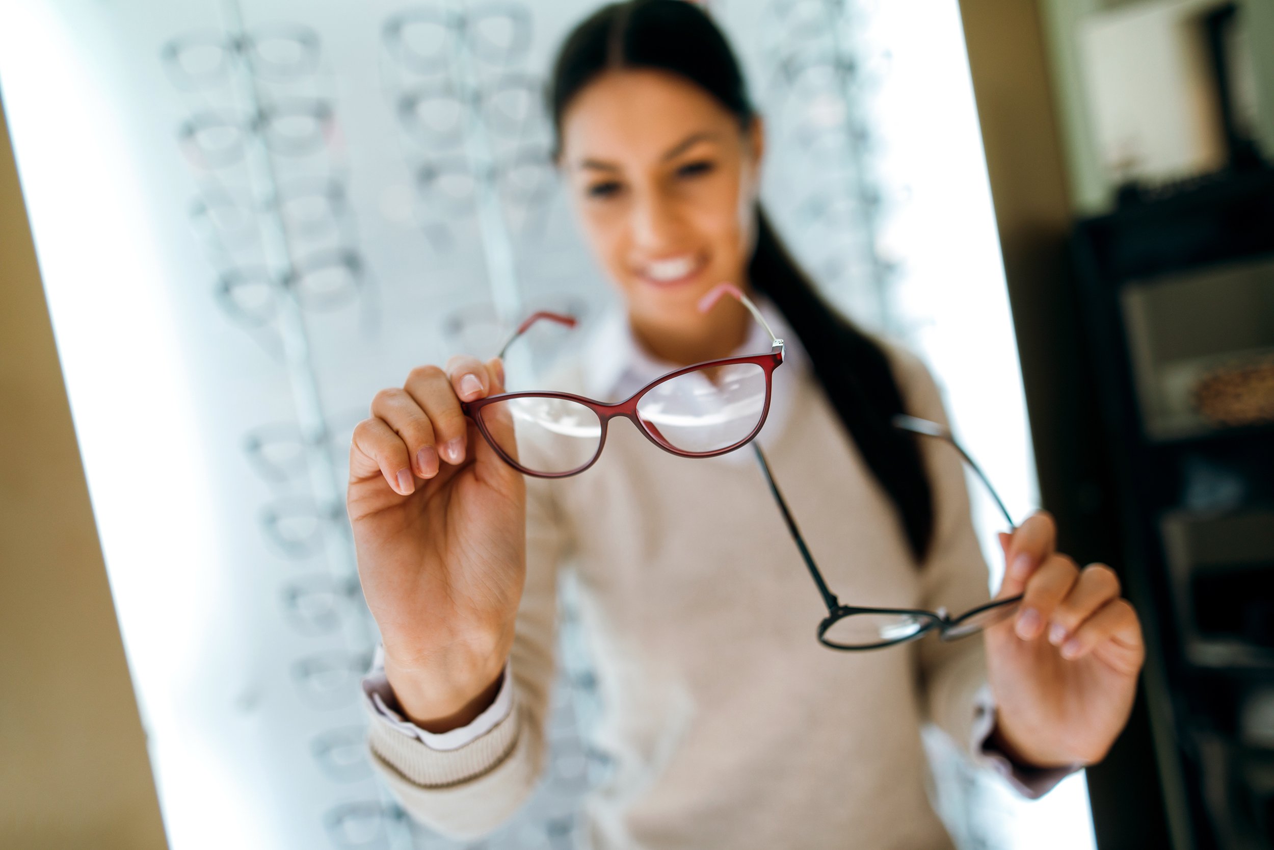 woman selecting eyeglasses in optical store