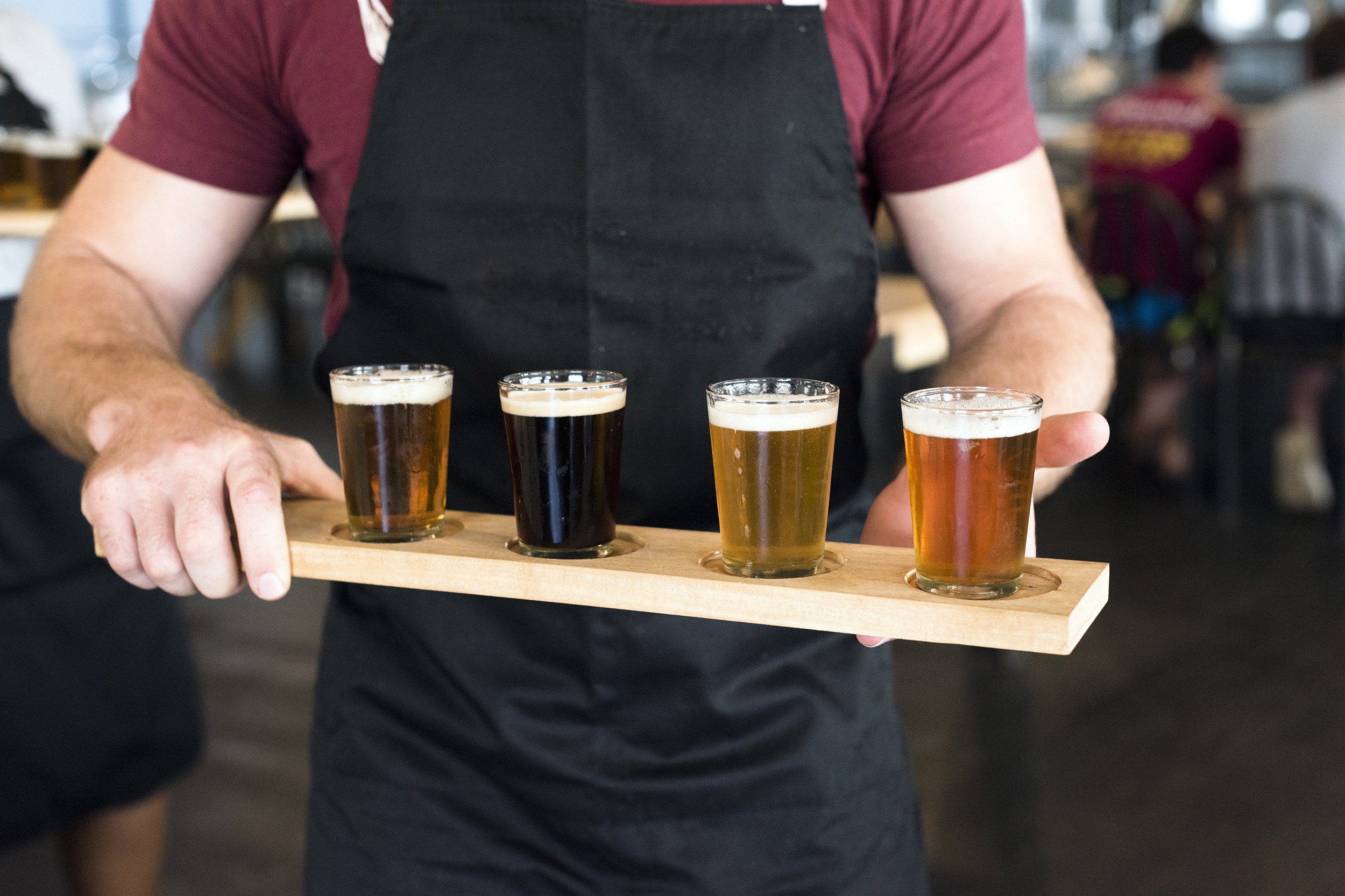 waiter carrying a tray of craft beer in glasses